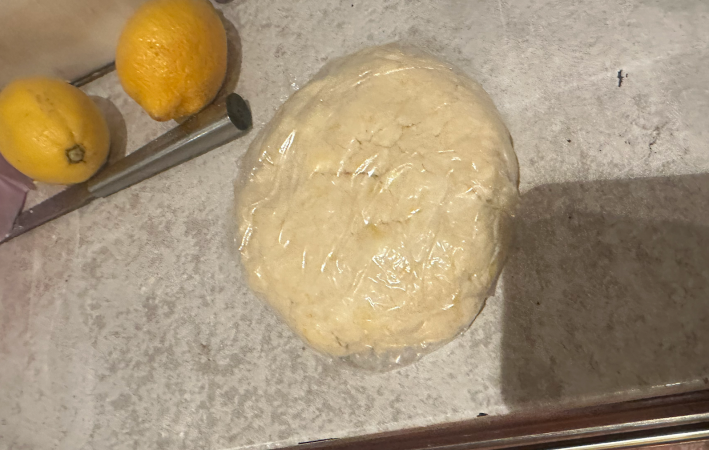 ball of dough on the counter wrapped in plastic wrap