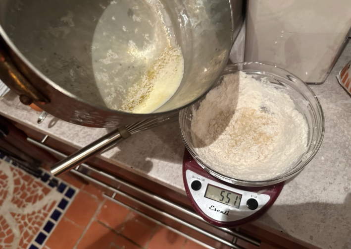 pouring butter into a bowl with flour