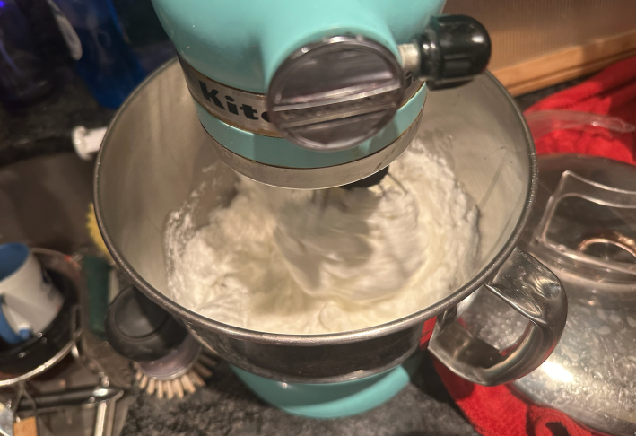 egg whites whipping in a blue kitchen aid