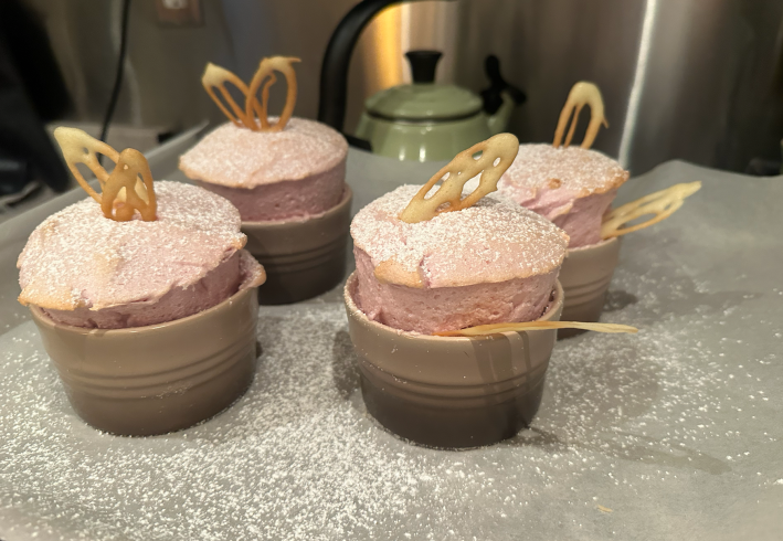 four risen souffles with little leaves and powdered sugar on top