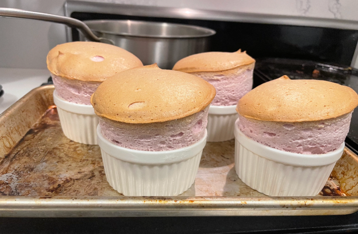 four nicely browned souffles in white cups