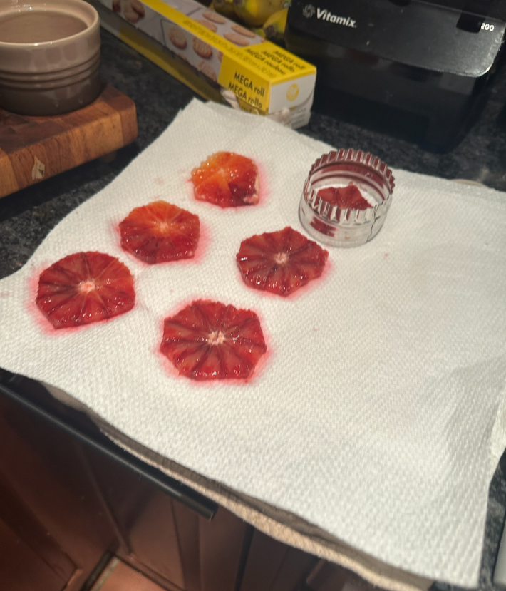 six blood orange slices on a stack of paper towels