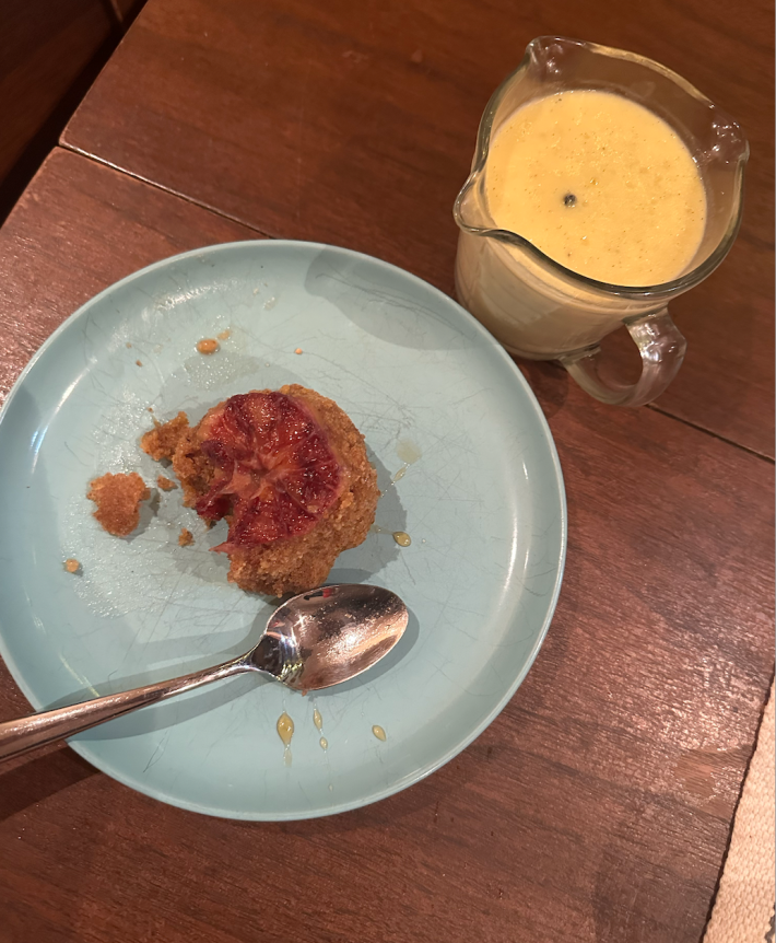 A pudding with a bite taken out of it and creme anglaise on the side