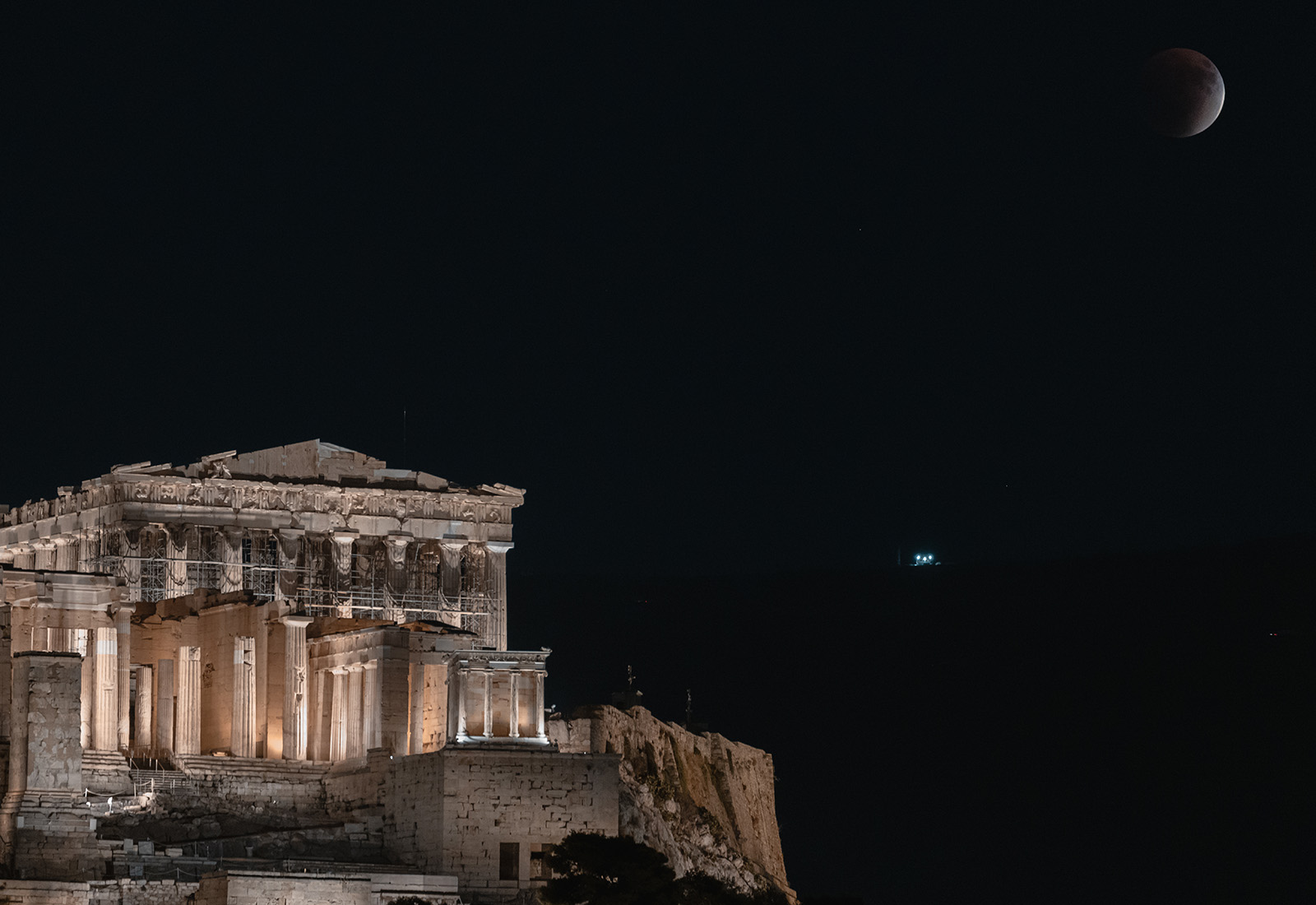 A total lunar eclipse, known as a ''blood moon,'' rises beside the illuminated Parthenon temple at the Acropolis in Athens, Greece, on September 7, 2025.