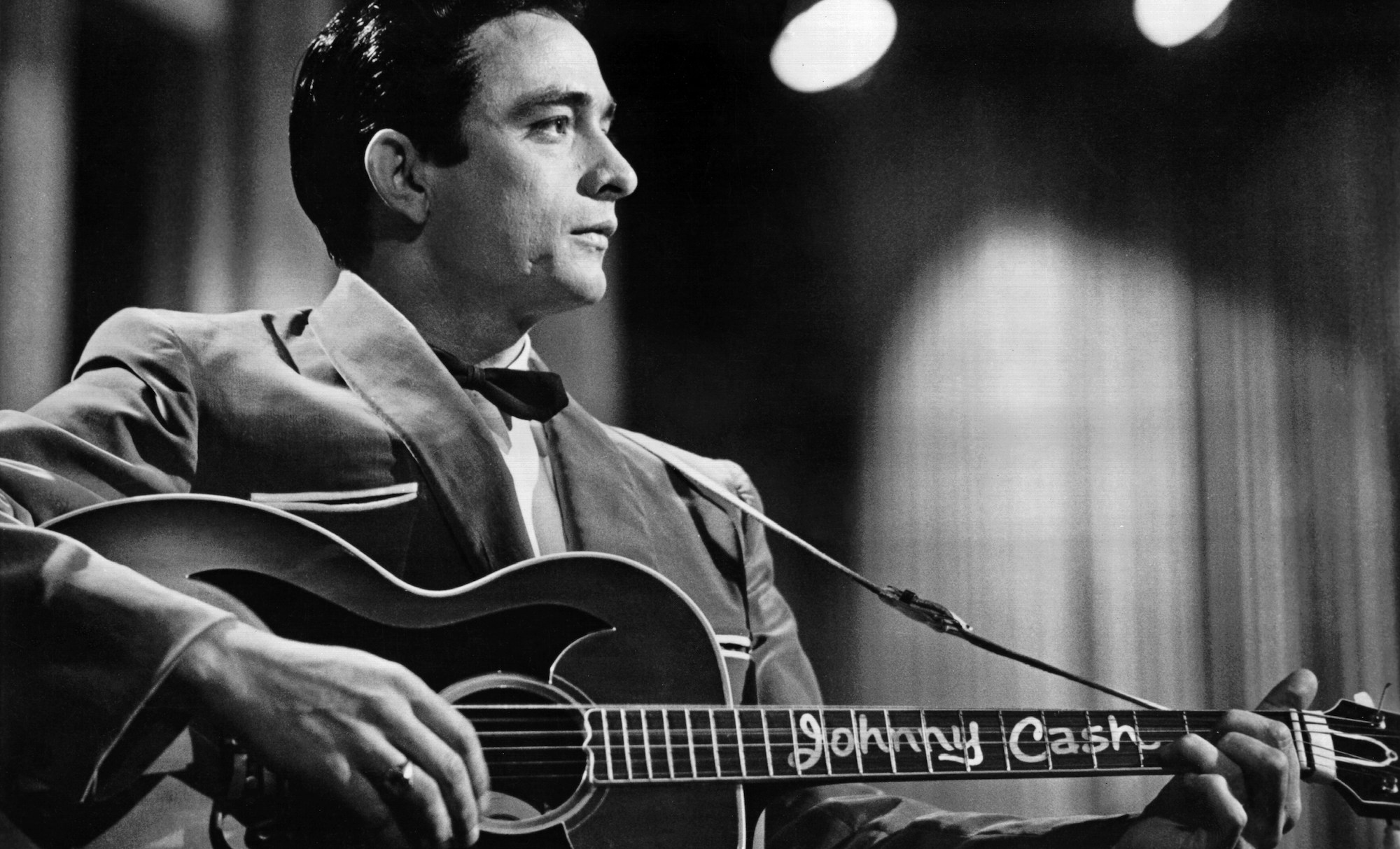 Country singer/songwriter Johnny Cash performs onstage with an acoustic guitar in Sun Records publicity shot in 1957.
