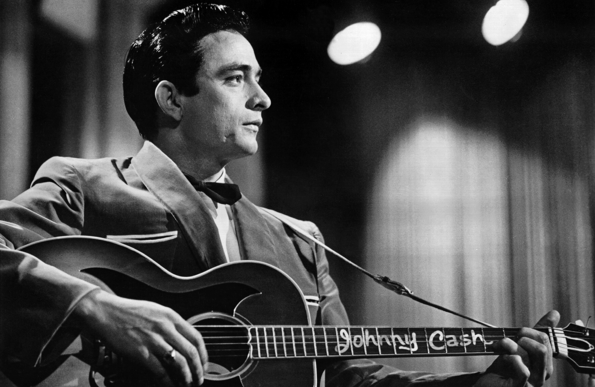 Country singer/songwriter Johnny Cash performs onstage with an acoustic guitar in Sun Records publicity shot in 1957.