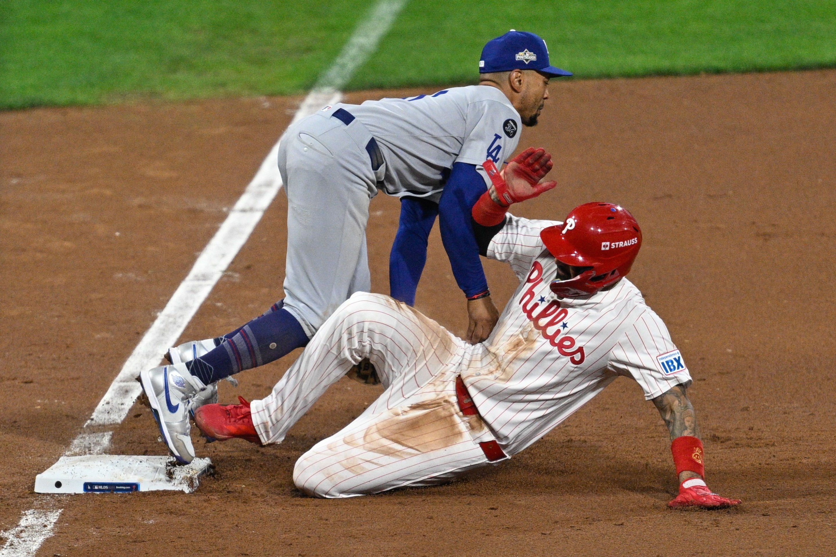 Philadelphia Phillies outfielder Nick Castellanos #8 slides into Los Angeles Dodgers shortstop Mookie Betts #50 on third base.