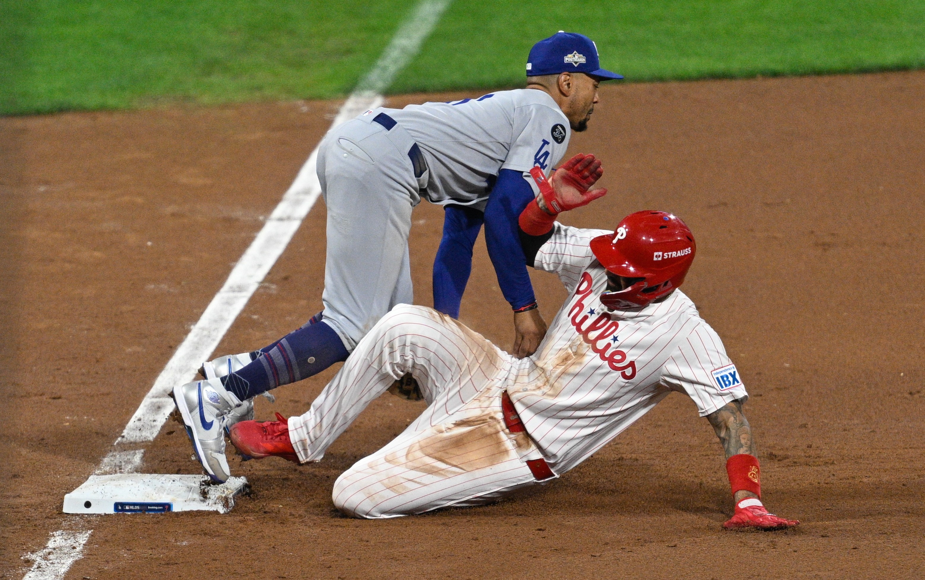 Philadelphia Phillies outfielder Nick Castellanos #8 slides into Los Angeles Dodgers shortstop Mookie Betts #50 on third base.