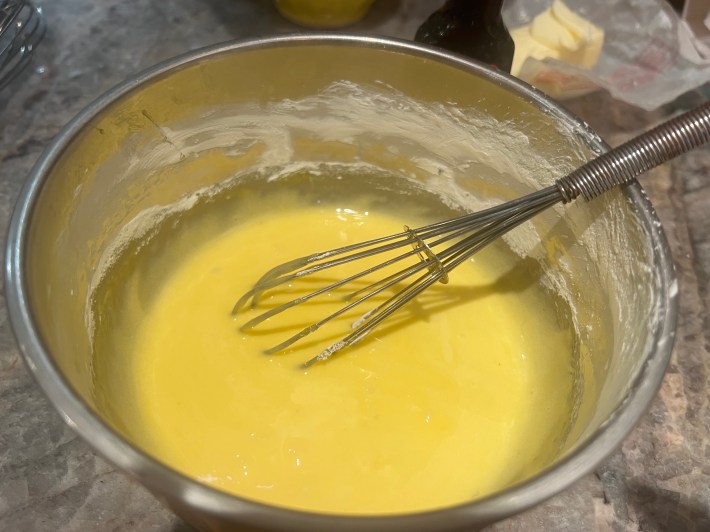 Egg yolks mixed with caster sugar, in a mixing bowl.