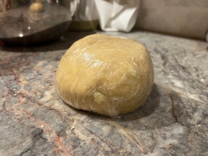 A ball of dough wrapped in plastic film.