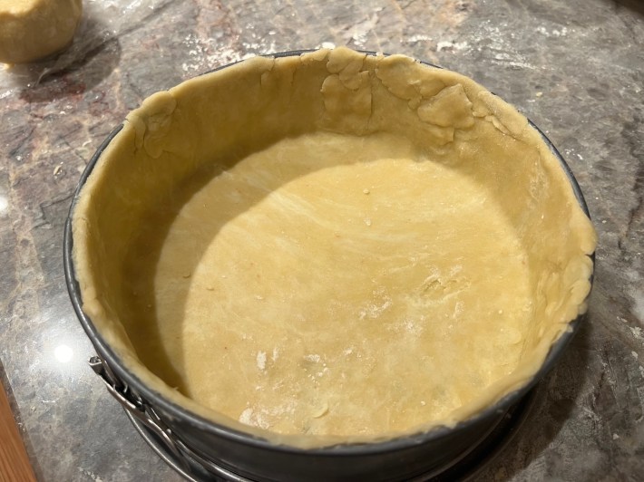 Dough smushed into a springform tin.