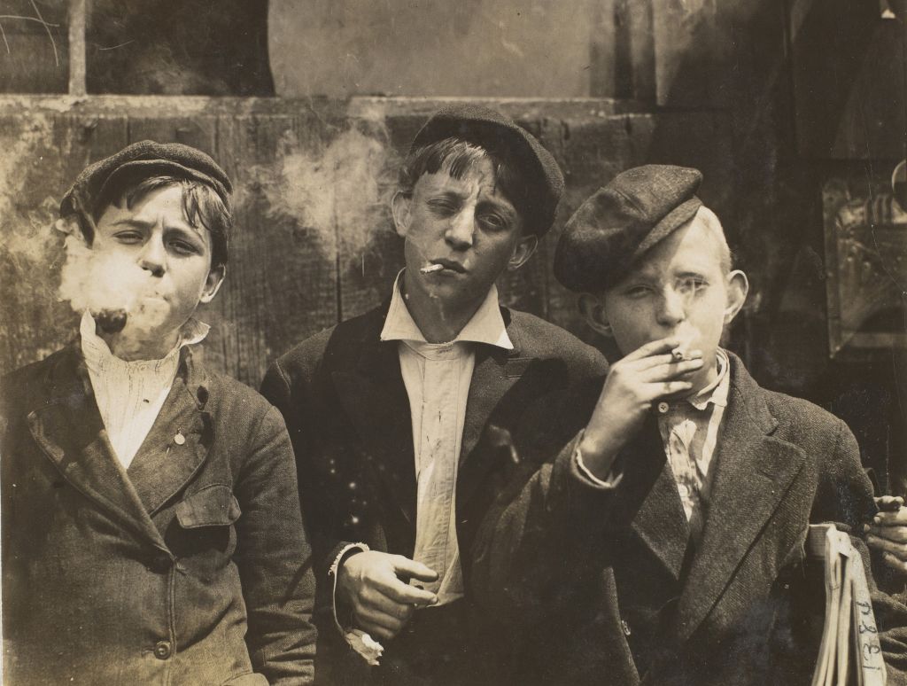 11:00 A.M. Monday. May 9th. 1910. Newsies at Skeeter's Branch. Jefferson near Franklin. They were all smoking. Location: St. Louis. Missouri. May 9. 1910. Gelatin silver print. 9.1 x 11.9 cm