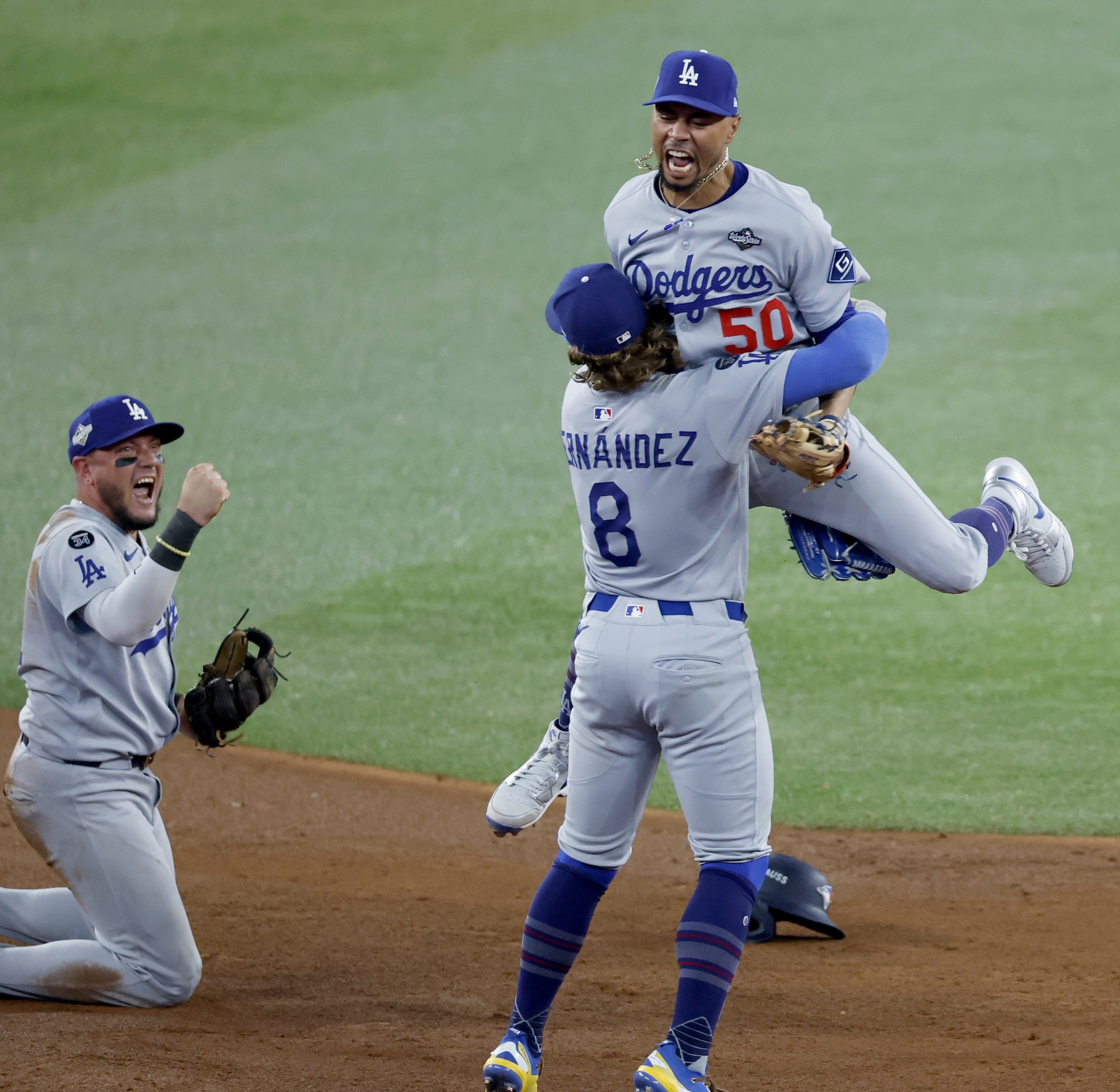 Toronto, Ontario, Canada October 31, 2025: Los Angeles Dodgers shortstop Mookie Betts (50) leaps to Los Angeles Dodgers first baseman Enrique Hernandez (8) after the final out while Toronto Blue Jays third baseman Addison Barger (47) is out at second in the ninth inning and Los Angeles Dodgers Miguel Rojas celebrates during game six of the World Series between the Los Angeles Dodgers and the Toronto Blue Jays at Roger Centre on Friday, October 31, 2025 in Los Angeles, CA.(Gina Ferazzi / Los Angeles Times via Getty Images)