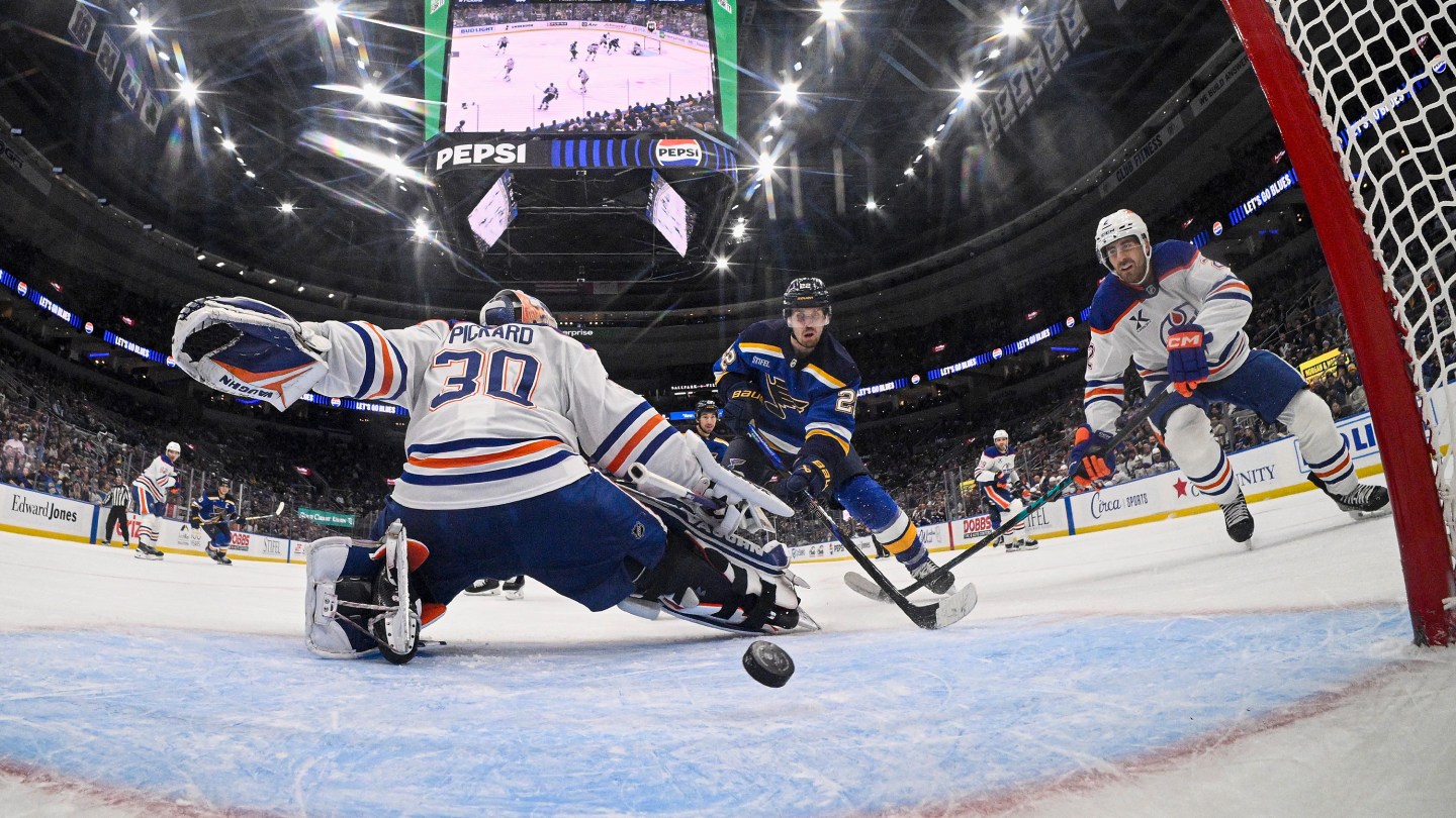 Pius Suter #22 of the St. Louis Blues scores the game winning goal as Calvin Pickard #30 and Evan Bouchard #2 of the Edmonton Oilers attempt to defend the net