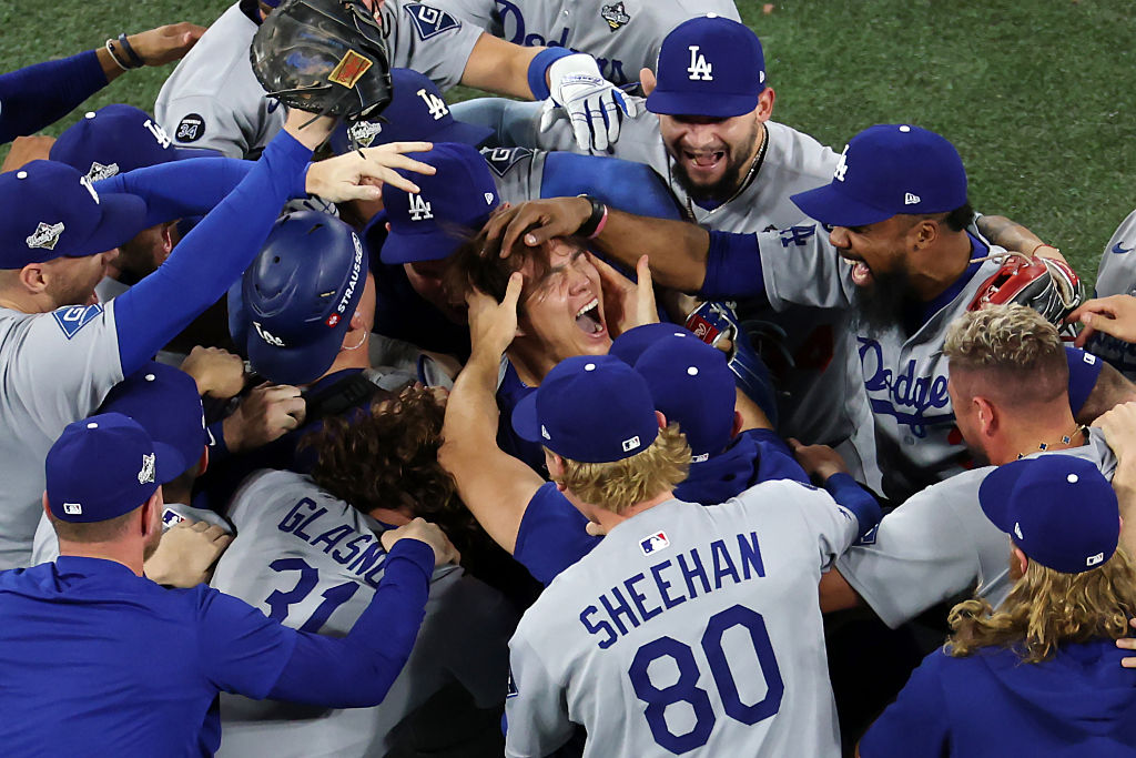 Los Angeles Dodgers pitcher Yoshinobu Yamamoto is mobbed by teammates as they celebrate winning the 2025 World Series against the Toronto Blue Jays 5-4
