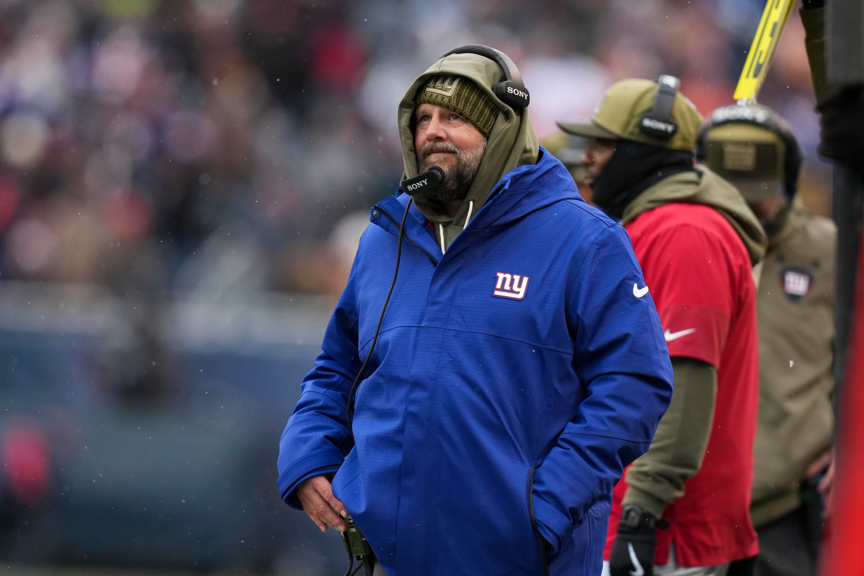 Brian Daboll of the New York Giants stands on the sideline during the second half of an NFL football game against the Chicago Bears on Sunday, November 9, 2025. It's snowing and he looks kind of frustrated.