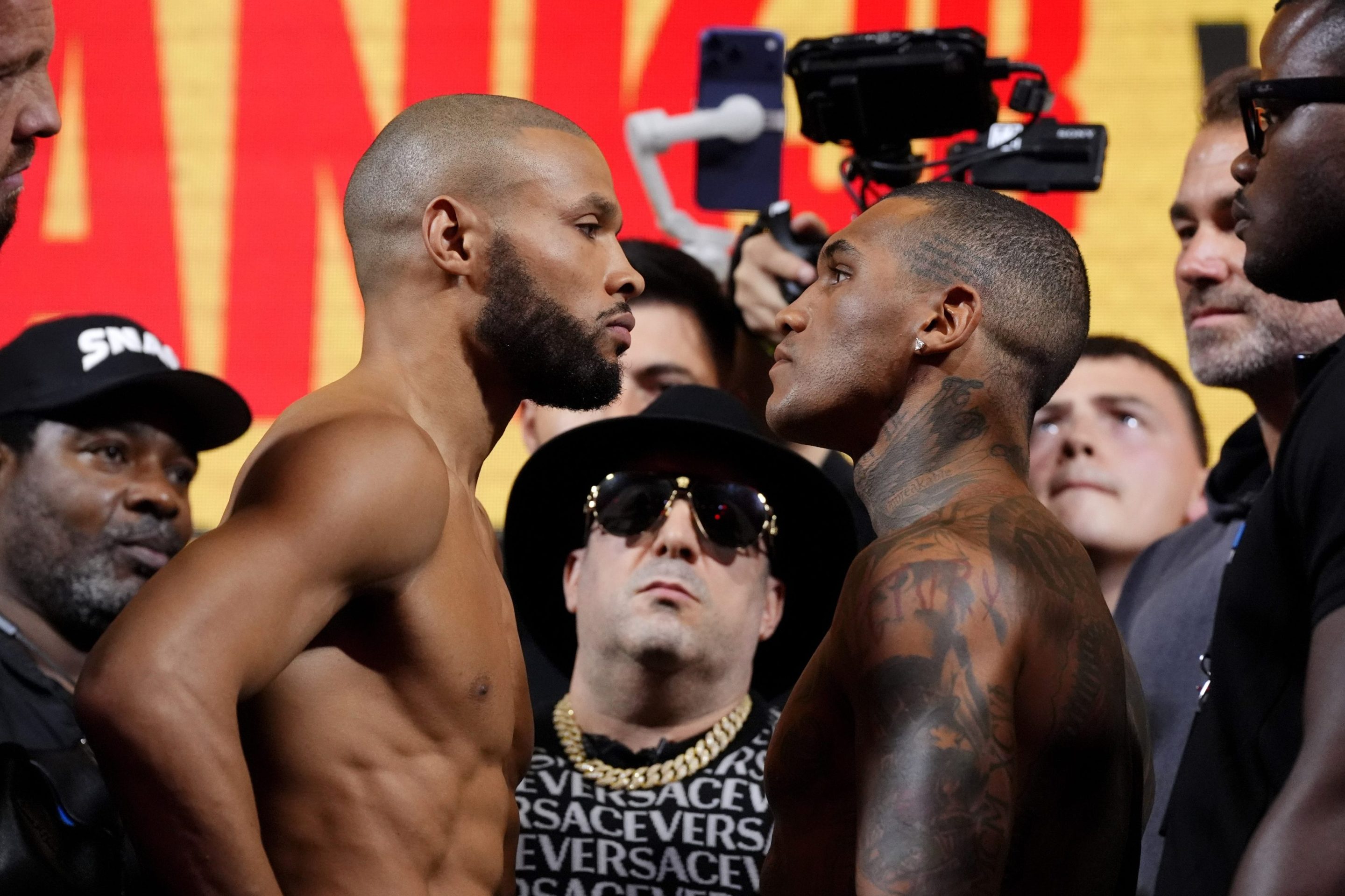 Chris Eubank Jr (left) and Conor Benn during the weigh-in at York Hall, London. They are staring each other in the face while surrounded by cameras.