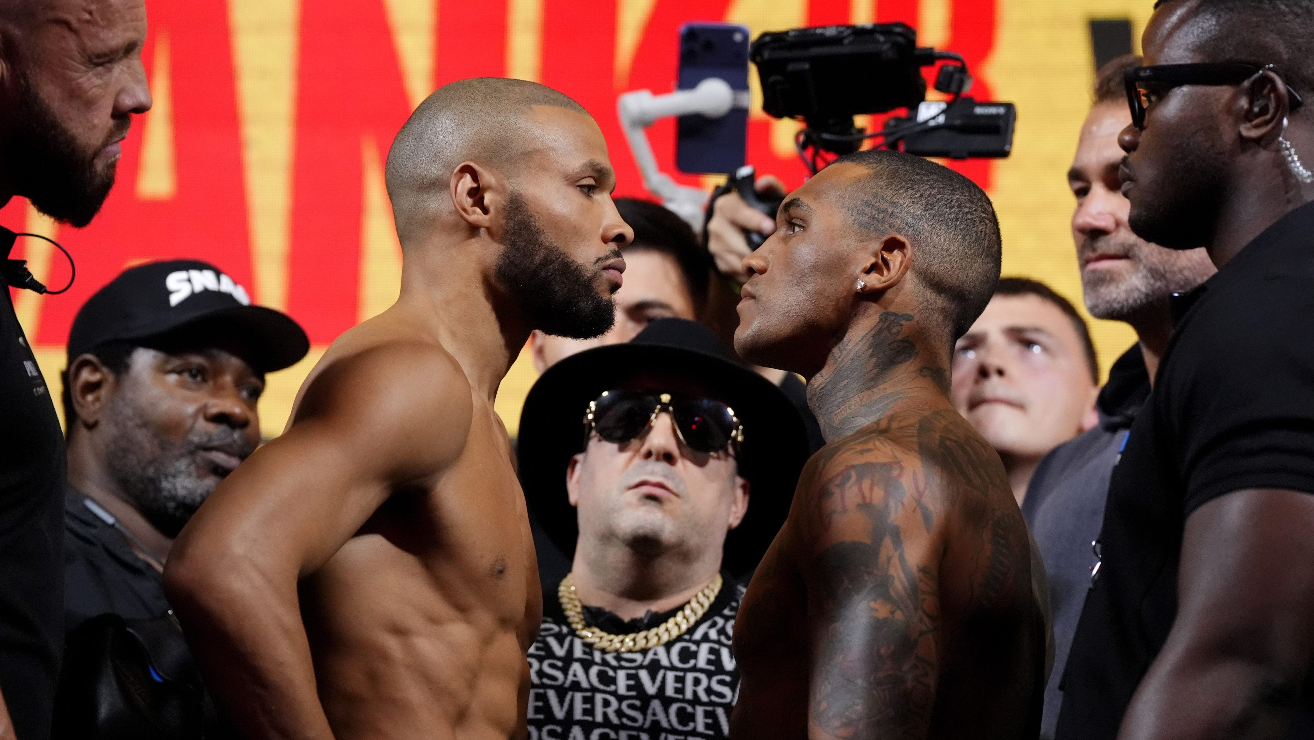 Chris Eubank Jr (left) and Conor Benn during the weigh-in at York Hall, London. They are staring each other in the face while surrounded by cameras.