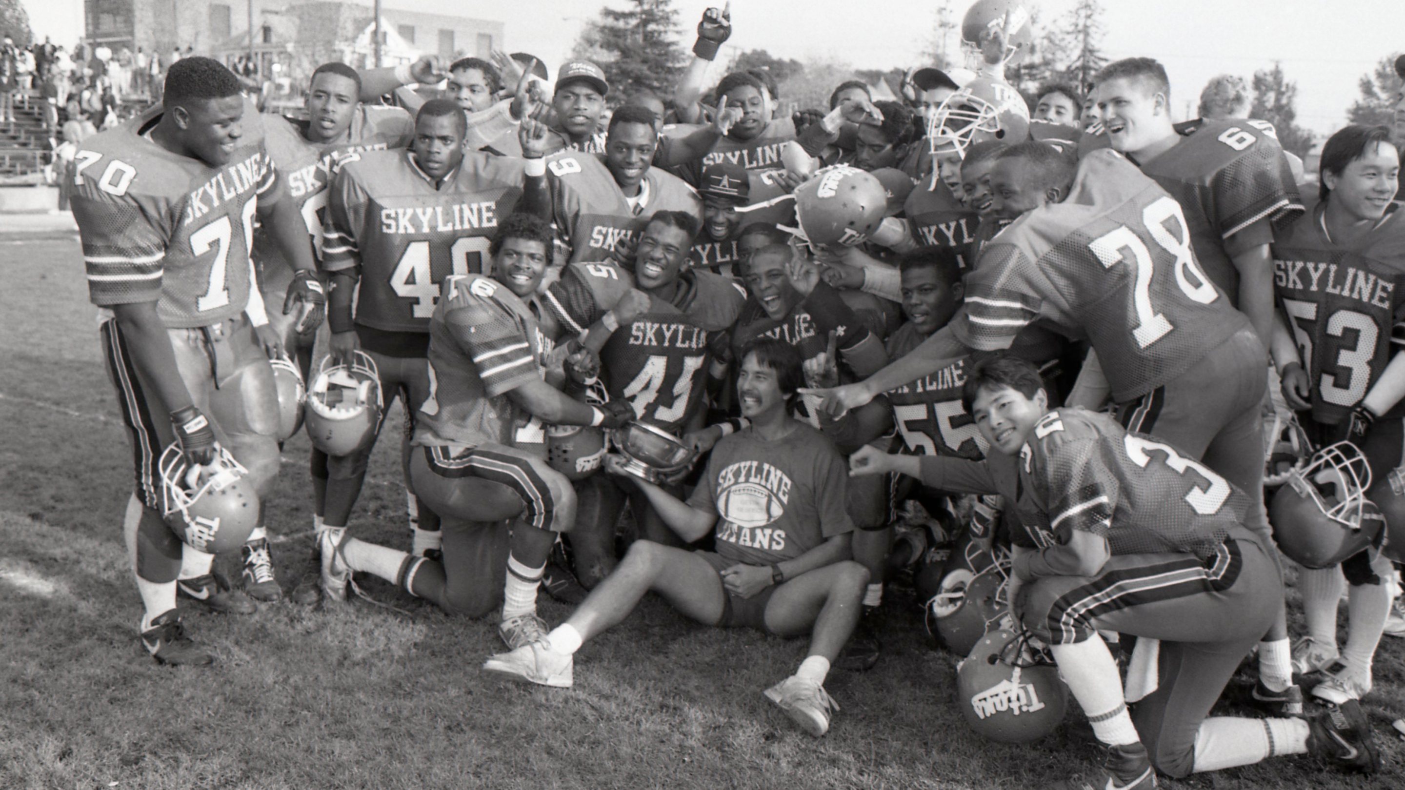 Coach John Beam, center bottom, and the Skyline High School football team pose together after beating Oakland High School 19-0 for the championship title at Laney College in Oakland, Calif. on Nov. 24, 1989.