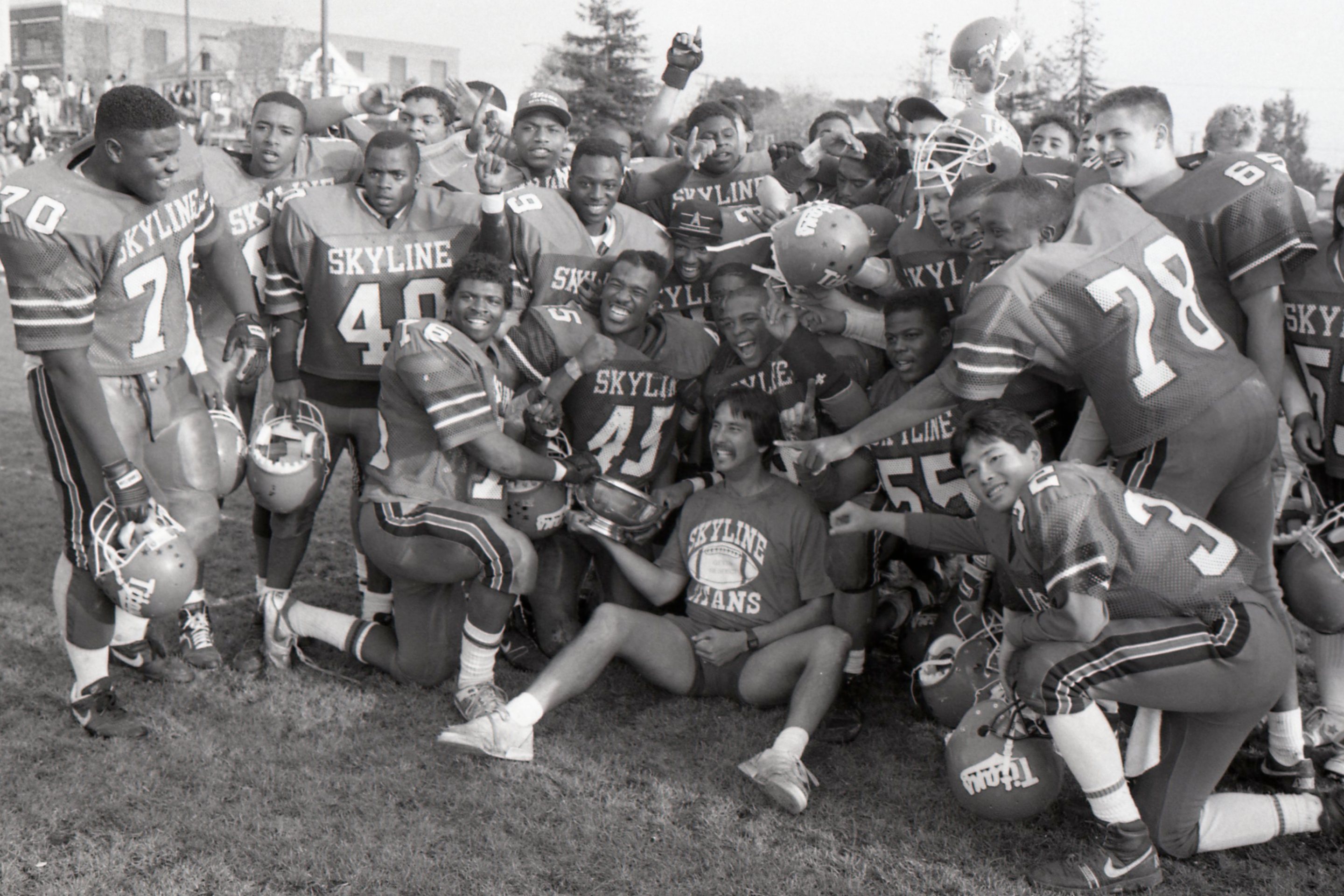 Coach John Beam, center bottom, and the Skyline High School football team pose together after beating Oakland High School 19-0 for the championship title at Laney College in Oakland, Calif. on Nov. 24, 1989.