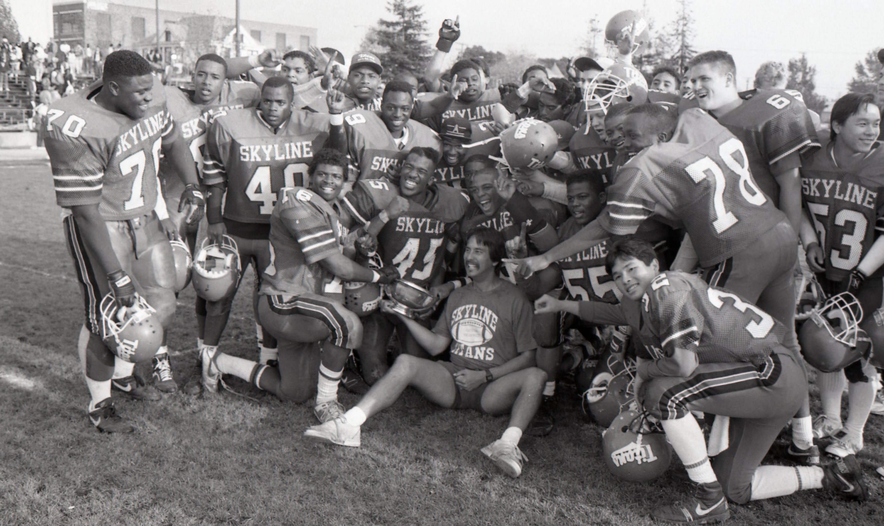 Coach John Beam, center bottom, and the Skyline High School football team pose together after beating Oakland High School 19-0 for the championship title at Laney College in Oakland, Calif. on Nov. 24, 1989.