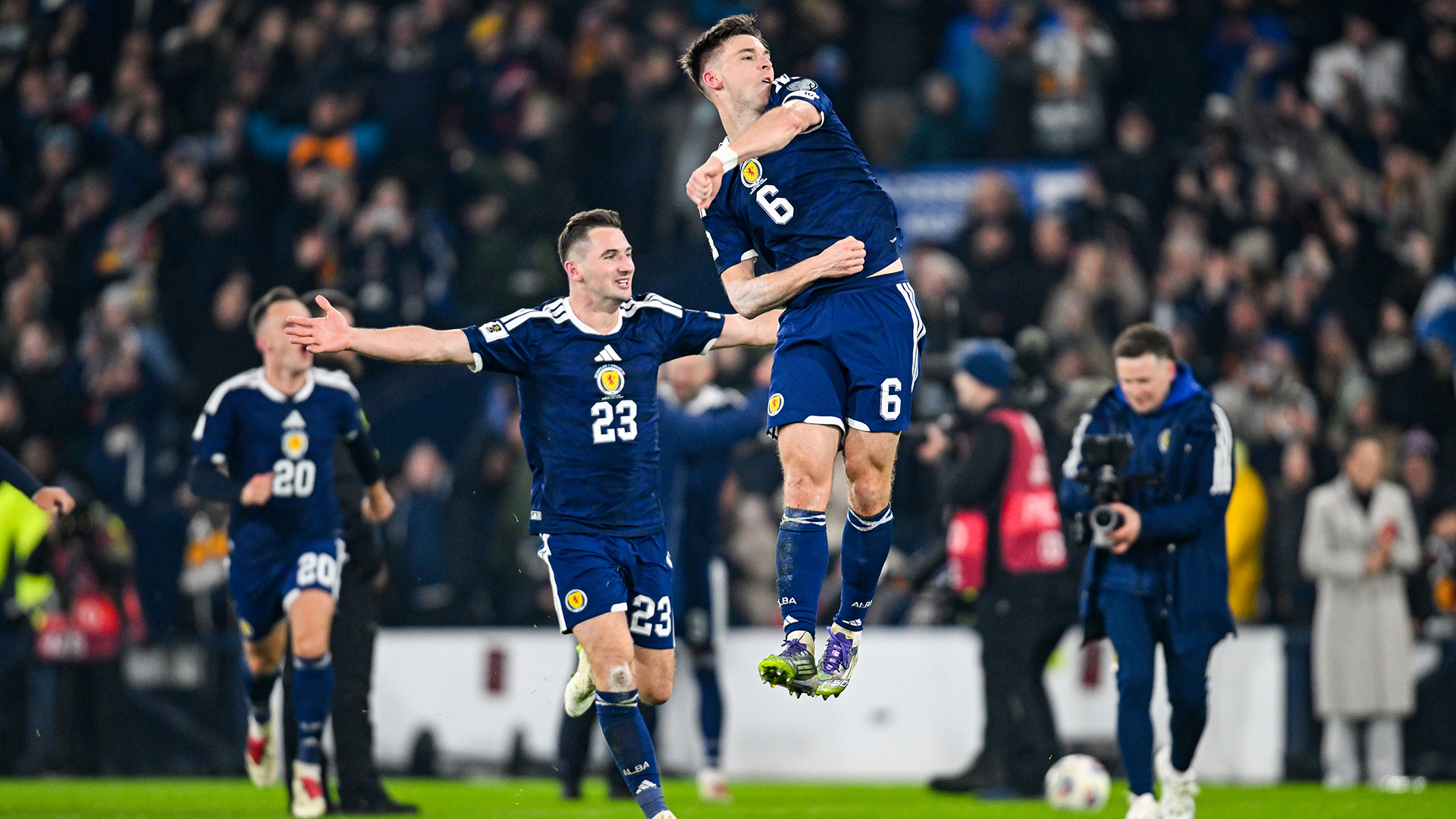 Scotland's Kieran Tierney (R) and Kenny McLean celebrate at full time during a FIFA World Cup 2026 Qualifier between Scotland and Denmark at Hampden Park, on November 18, 2025, in Glasgow, Scotland.