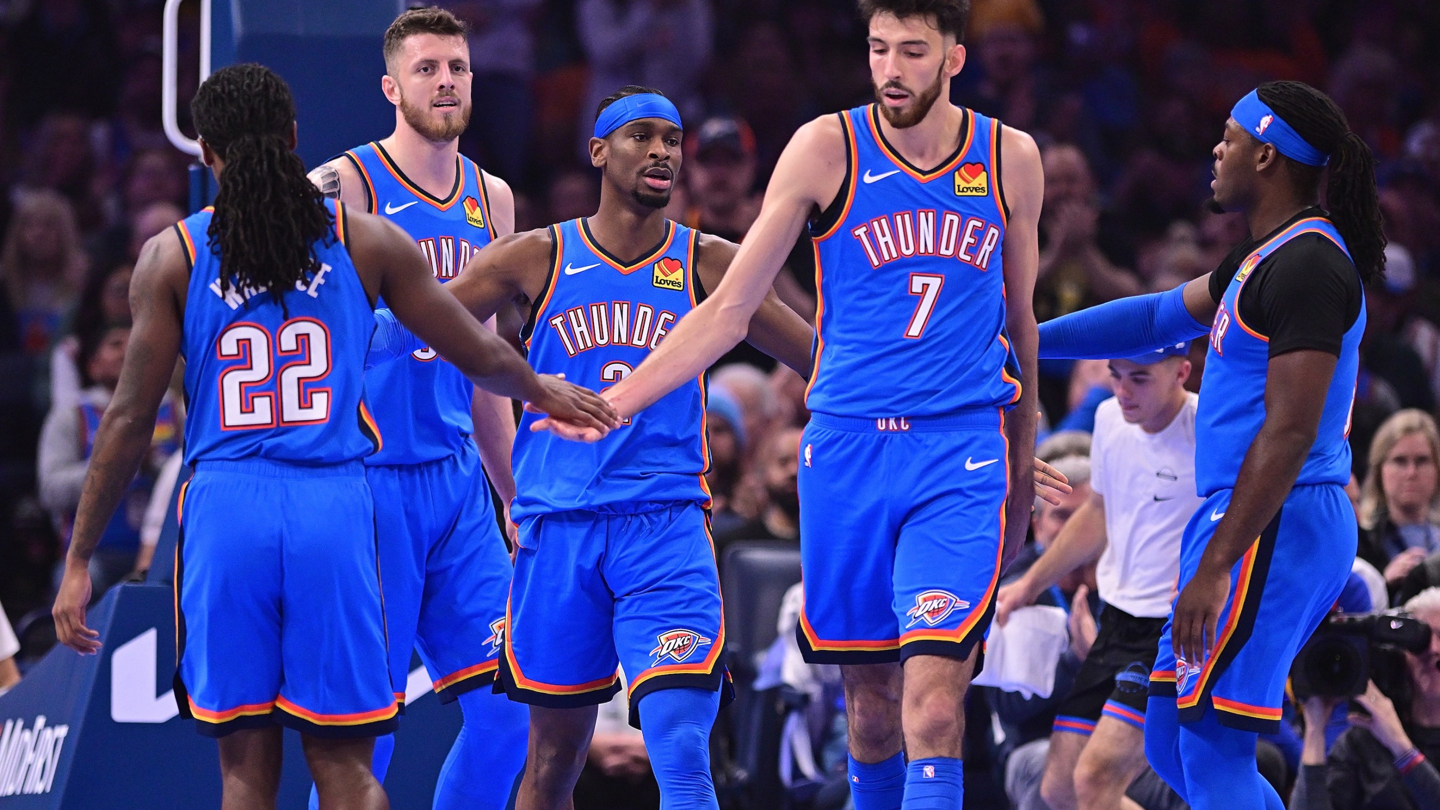 Cason Wallace #22, Isaiah Hartenstein #55, Shai Gilgeous-Alexander #2, Chet Holmgren #7, and Luguentz Dort #5 of the Oklahoma City Thunder celebrate during the first half against the Portland Trail Blazers on November 23, 2025.