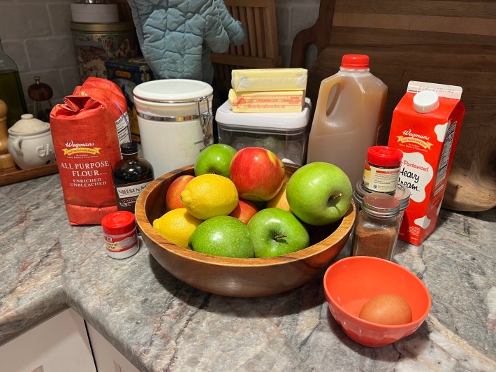 Ingredients for an apple pie, on a countertop.
