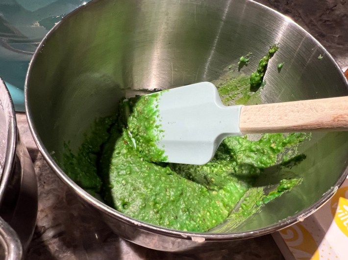 A green blob of marzipan, in a mixing bowl.