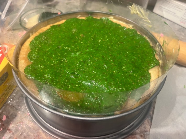 Lime-green marzipan smushed across the top sponge of a cake.