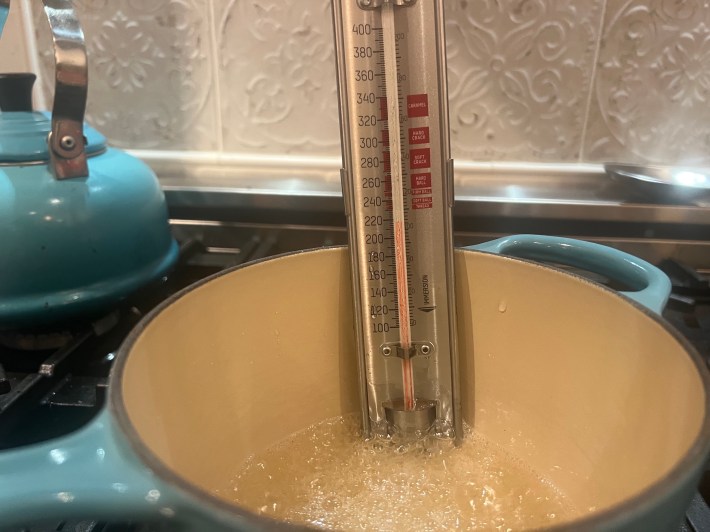 A sugar thermometer in cooking sugar.