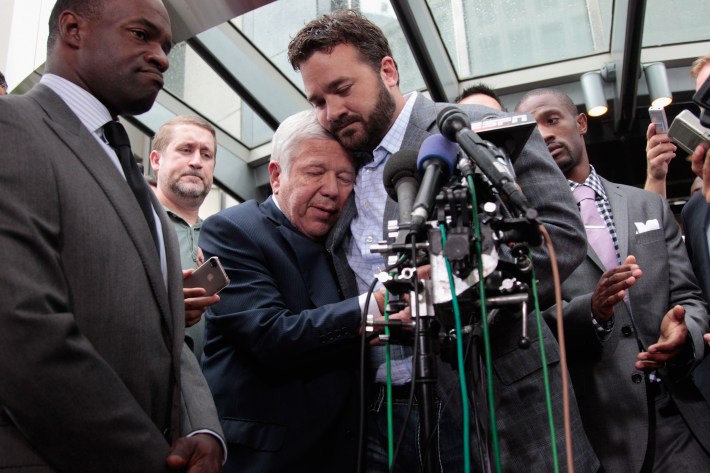 DeMaurice Smith (L) executive director of the National Football League Players' Association looks on as New England Patriots owner Robert Kraft (C) is embraced by Indianapolis Colts center Jeff Saturday (R) during a news conference on July 25, 2011 in Washington, DC. The NFL players and owners are set to agree on a labor deal and end the current lockout.
