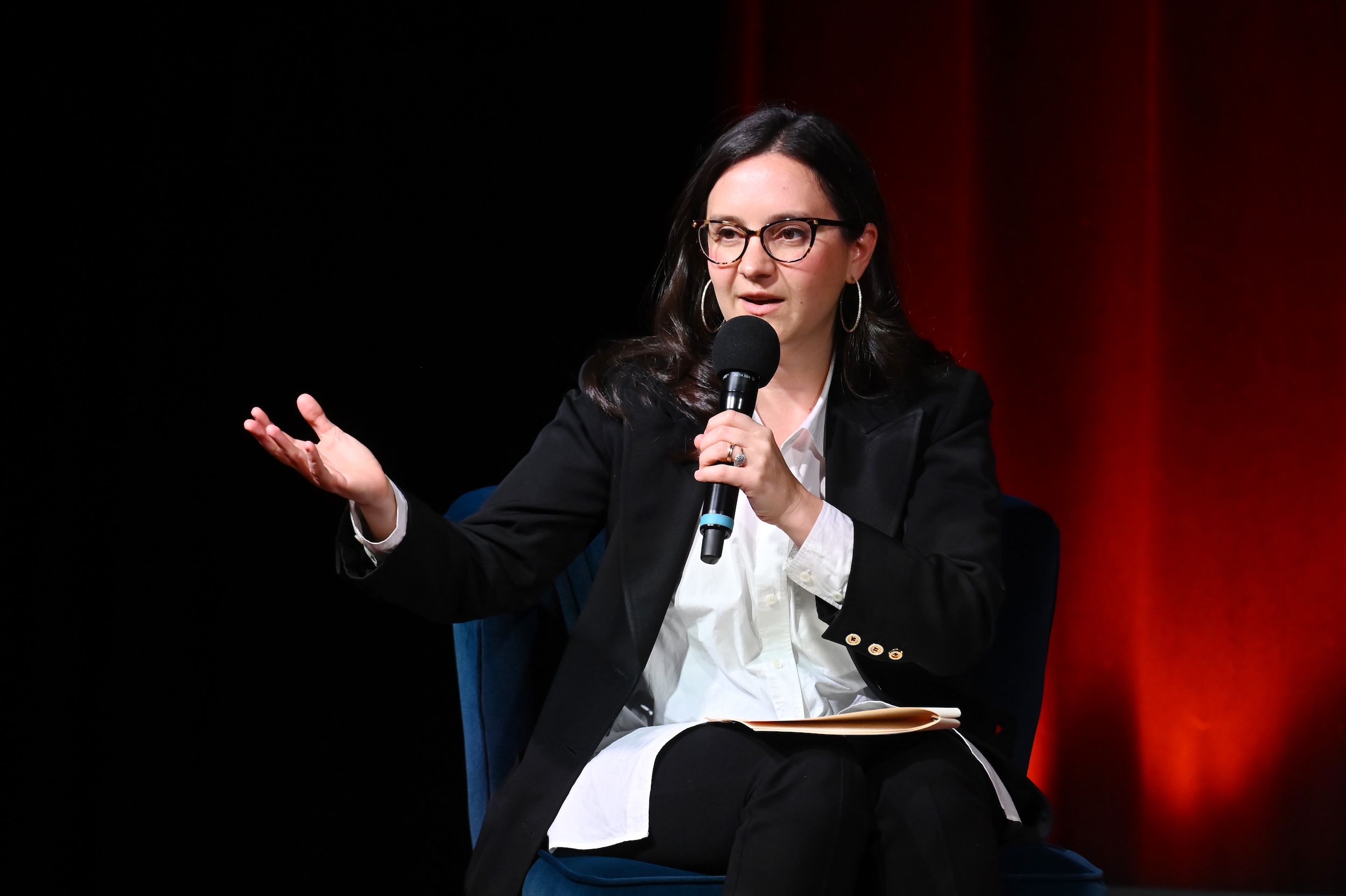 Bari Weiss gestures to a crowd.