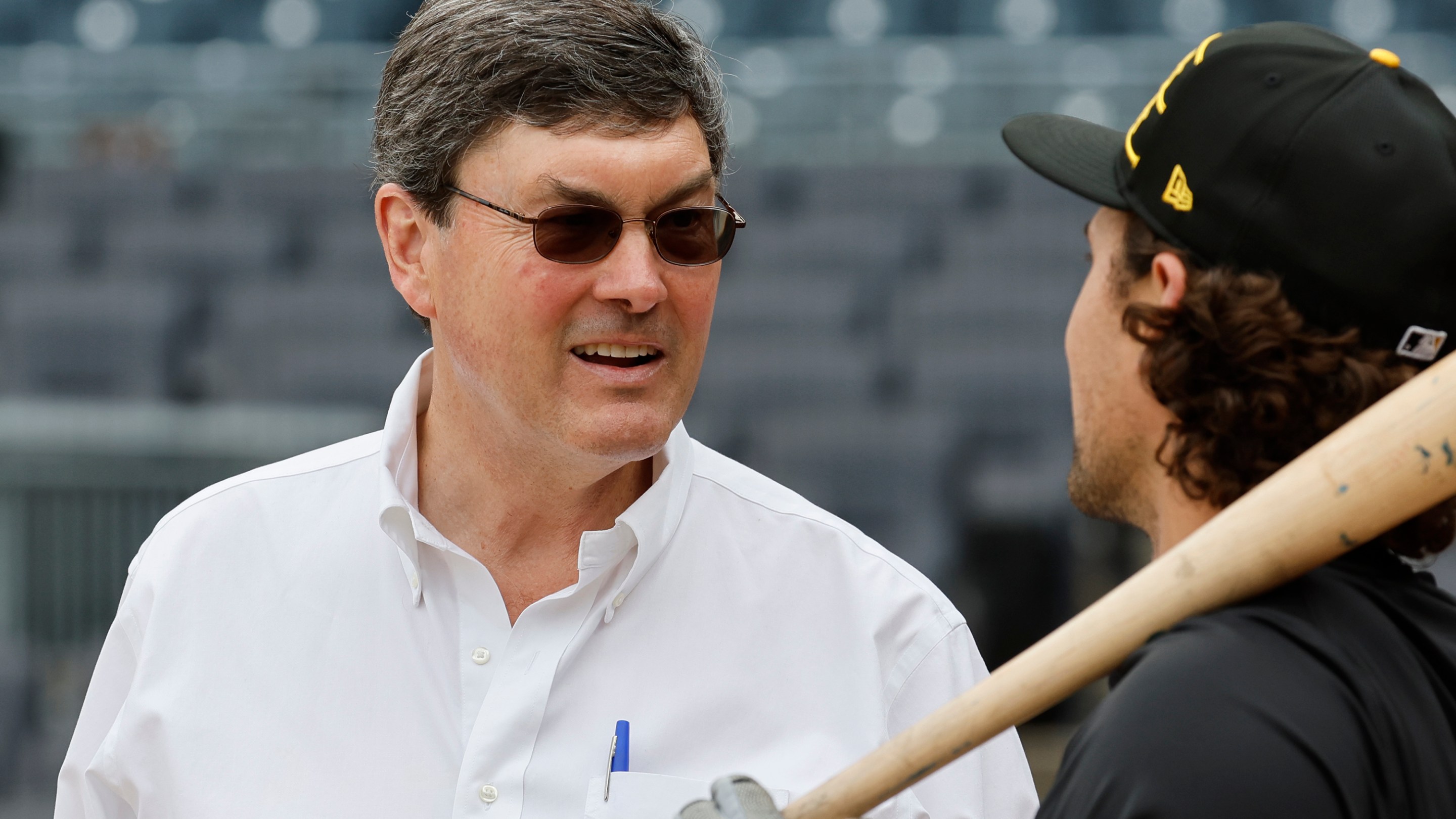 ob Nutting of the Pittsburgh Pirates talks with Adam Frazier #26 before the game against the New York Yankees during the home opener at PNC Park on April 4, 2025. He's got weird little sunglasses on. He looks like he's in a disguise somehow.