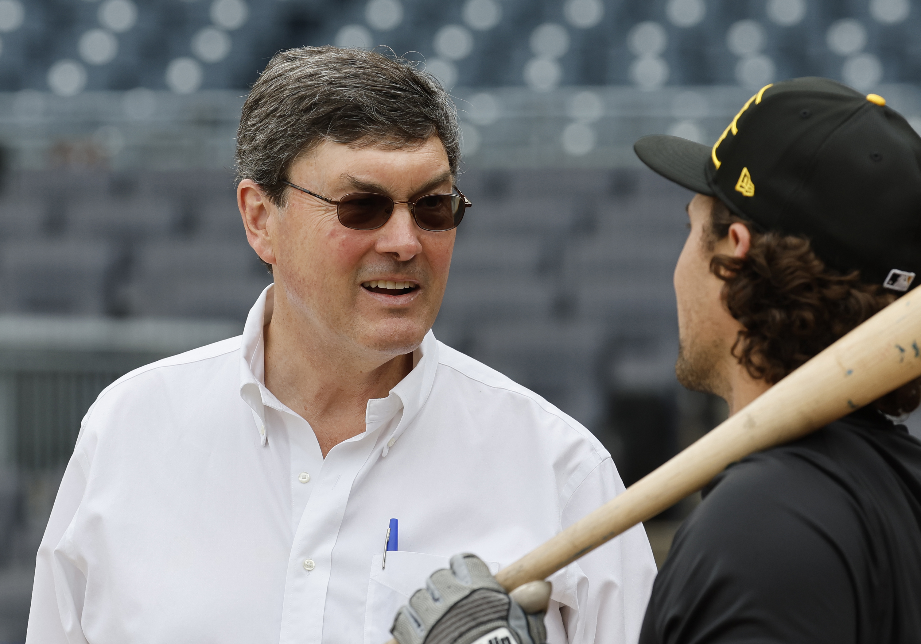 ob Nutting of the Pittsburgh Pirates talks with Adam Frazier #26 before the game against the New York Yankees during the home opener at PNC Park on April 4, 2025. He's got weird little sunglasses on. He looks like he's in a disguise somehow.