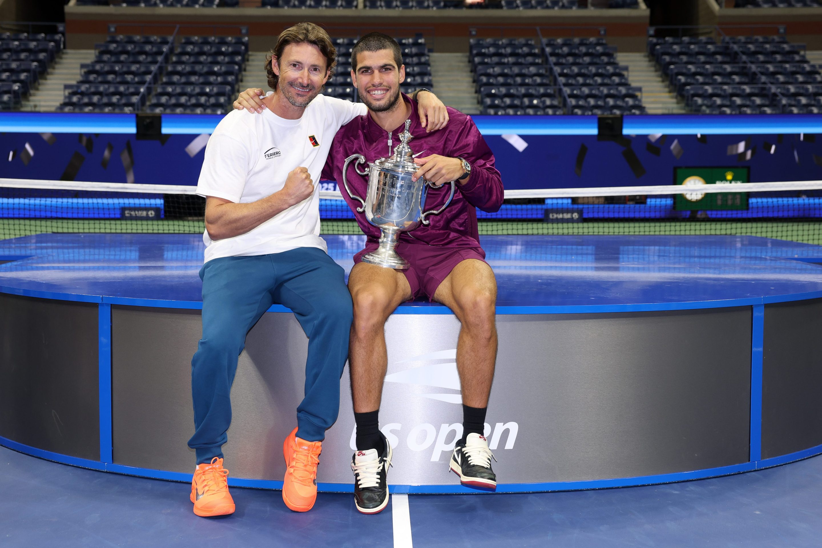 Carlos Alcaraz of Spain poses with his trophy next to his coach Juan Carlos Ferrero