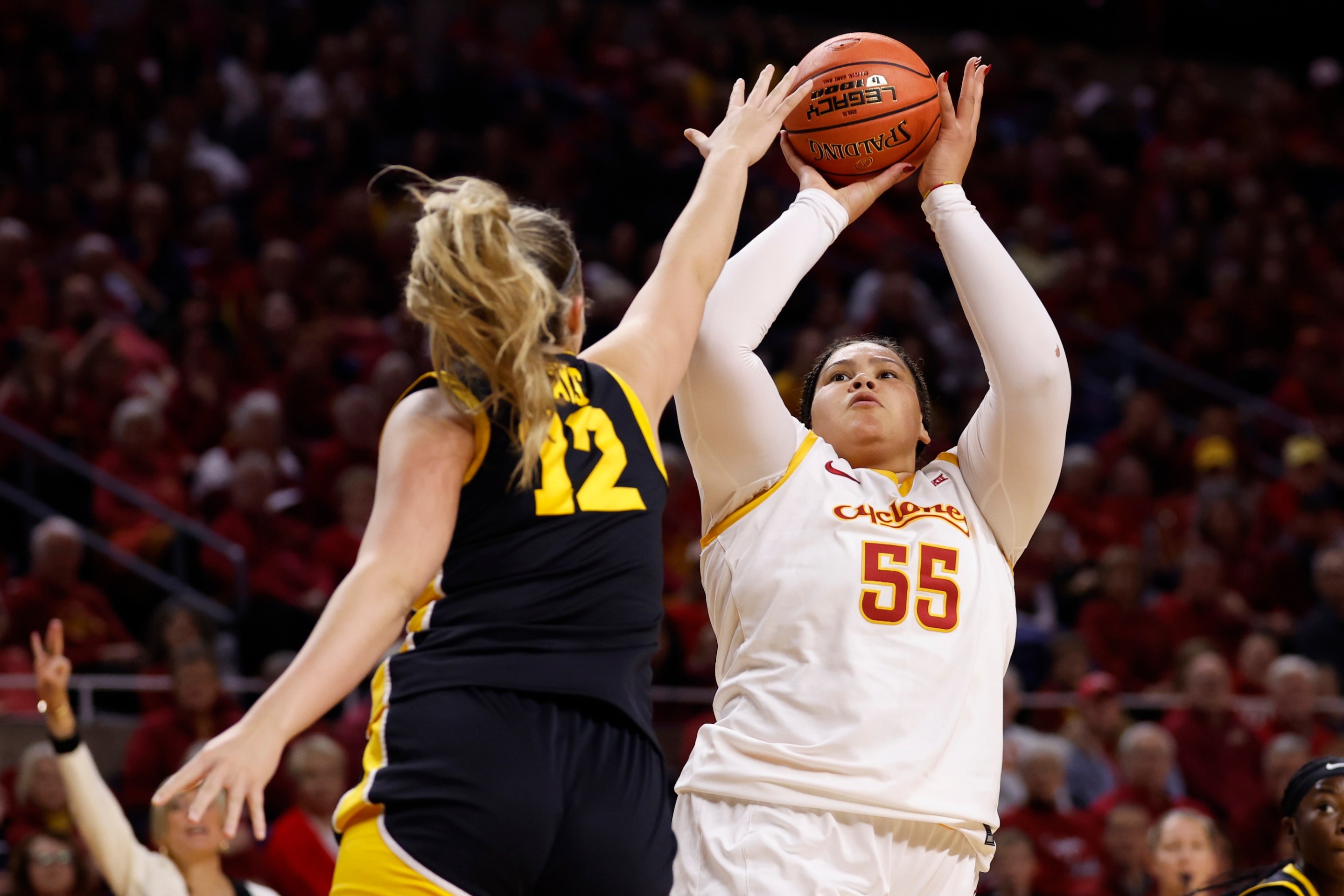 Audi Crooks #55 of the Iowa State Cyclones takes a shot as Layla Hays #12 of the Iowa Hawkeyes blocks in the first half of play at Hilton Coliseum on December 10, 2025, in Ames, Iowa.