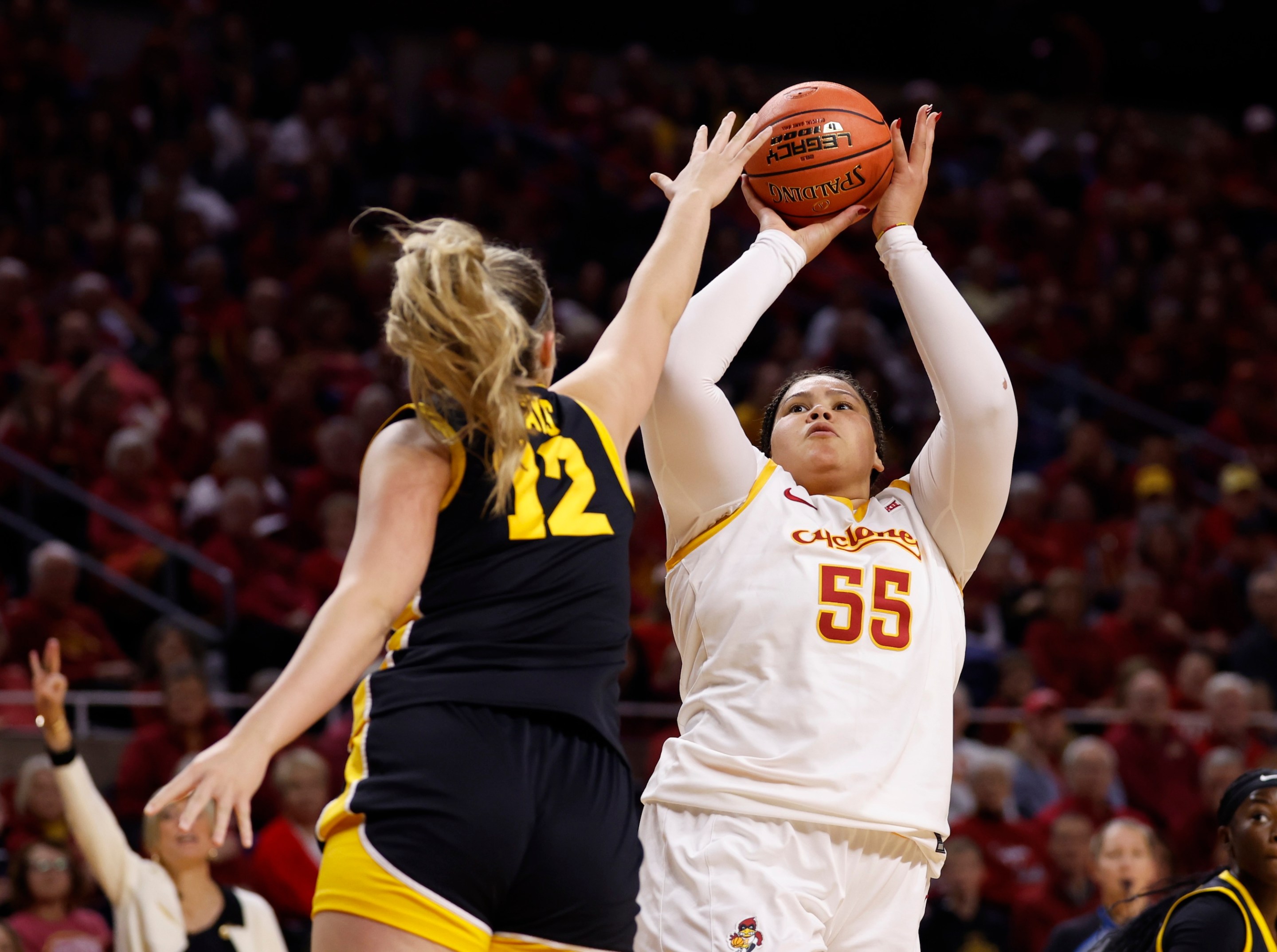 Audi Crooks #55 of the Iowa State Cyclones takes a shot as Layla Hays #12 of the Iowa Hawkeyes blocks in the first half of play at Hilton Coliseum on December 10, 2025, in Ames, Iowa.
