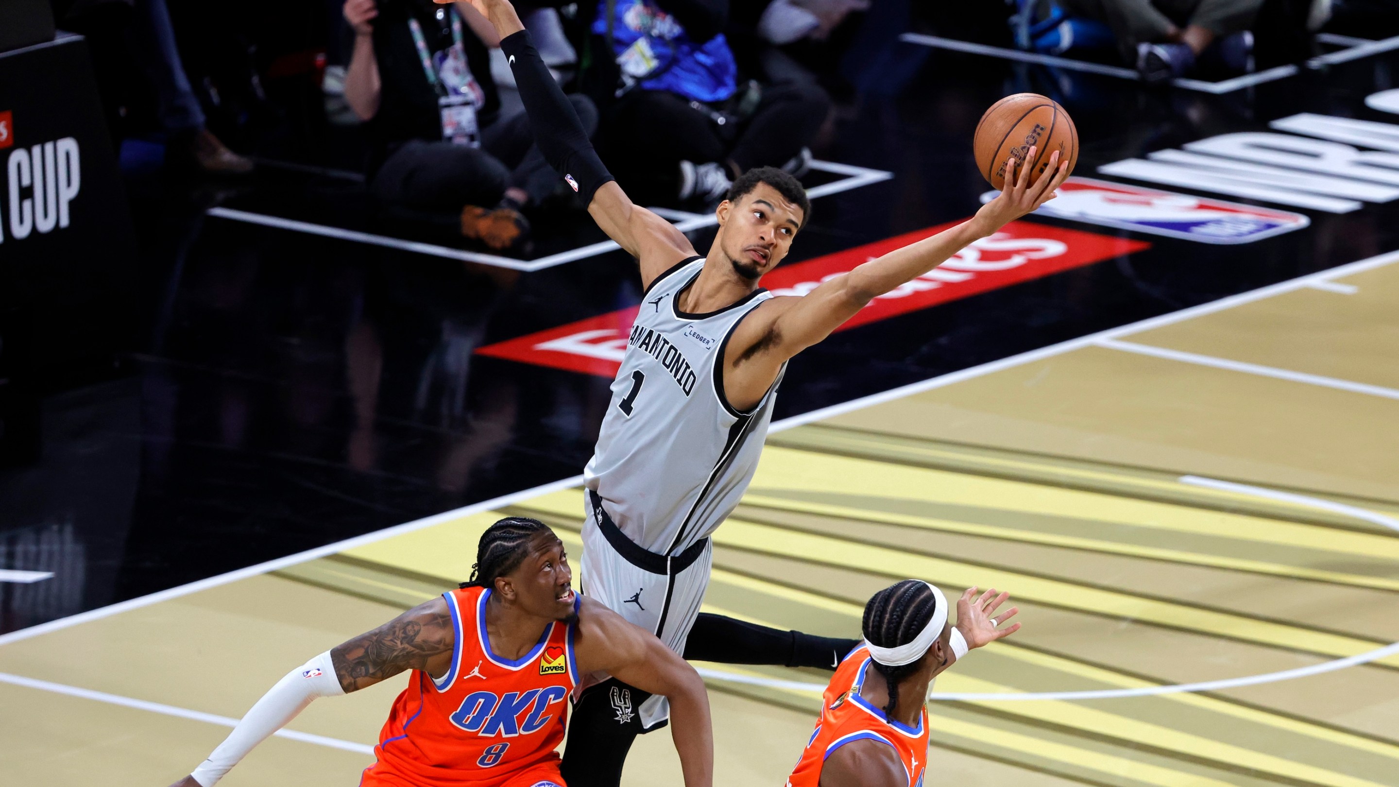 Victor Wembanyama and his long ass arms grab a rebound over Jaylen Williams of the Thunder during the fourth quarter of a semifinal game of the Emirates NBA Cup at T-Mobile Arena on December 13, 2025 in Las Vegas, Nevada.
