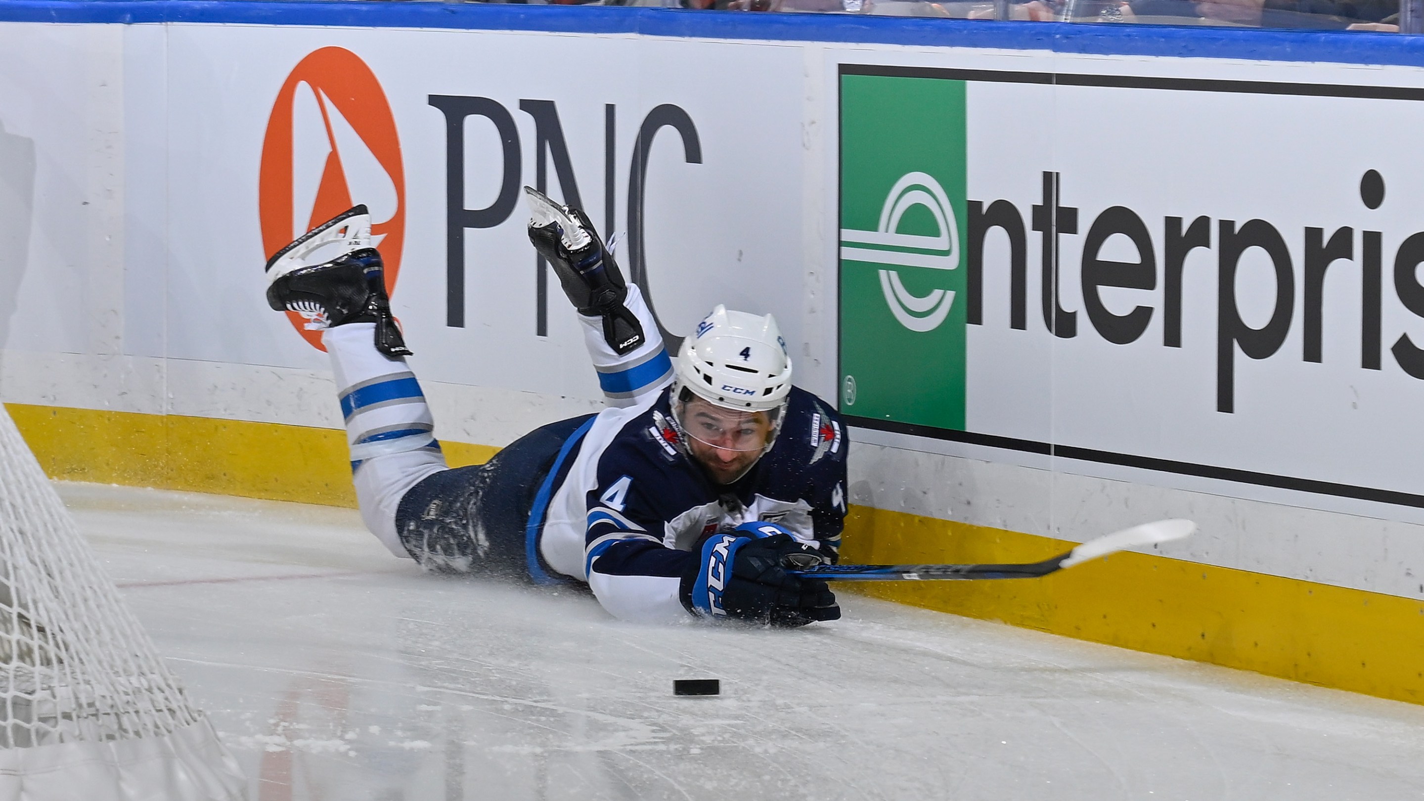 Neal Pionk #4 of the Winnipeg Jets falls to the ice during the game against the St. Louis Blues on December 17, 2025 at the Enterprise Center in St. Louis, Missouri.