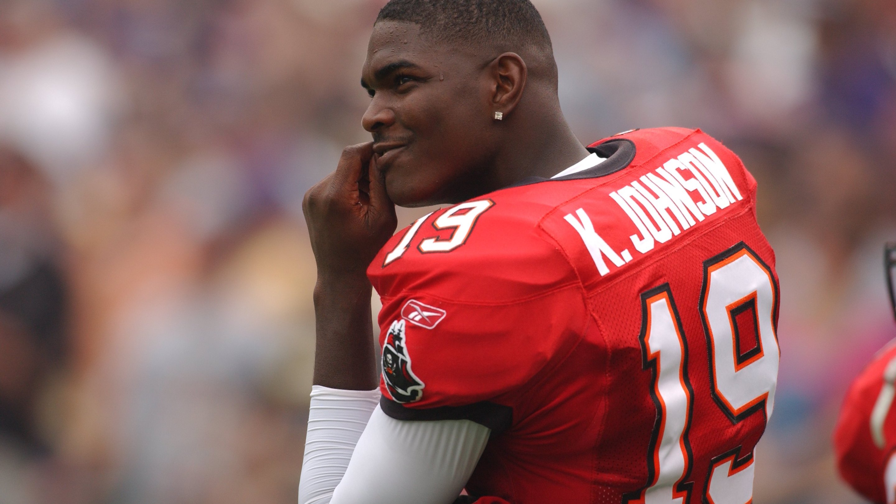 Keyshawn Johnson of the Tampa Bay Buccaneers looks on during a NFL football game against the Baltimore Ravens on September 15, 2002. He's kind of smirking a bit.