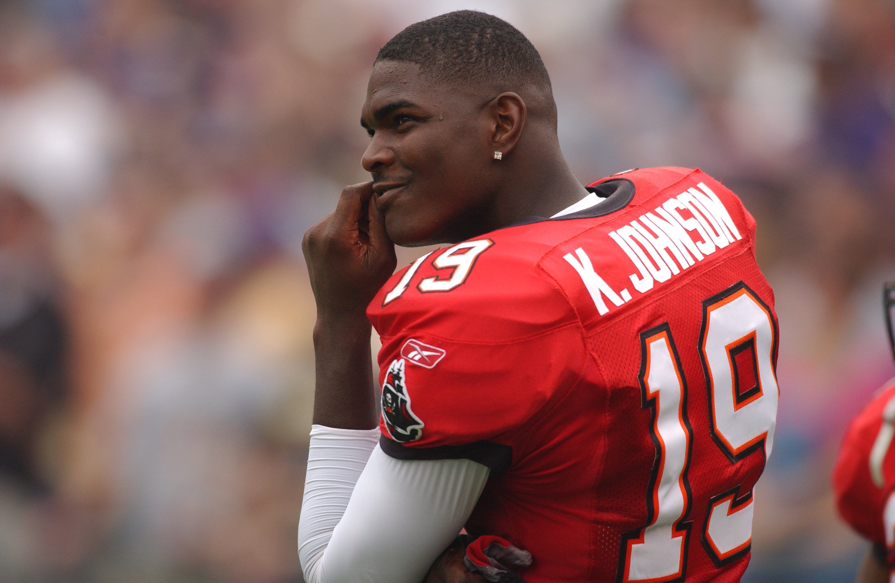 Keyshawn Johnson of the Tampa Bay Buccaneers looks on during a NFL football game against the Baltimore Ravens on September 15, 2002. He's kind of smirking a bit.