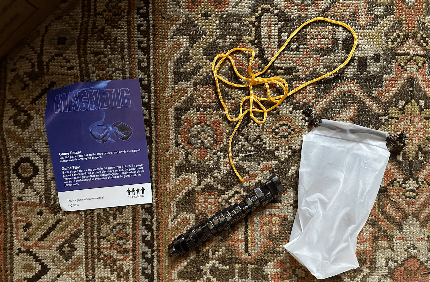 a piece of paper that says magnetic, a string, and a strange bag on top of a rug
