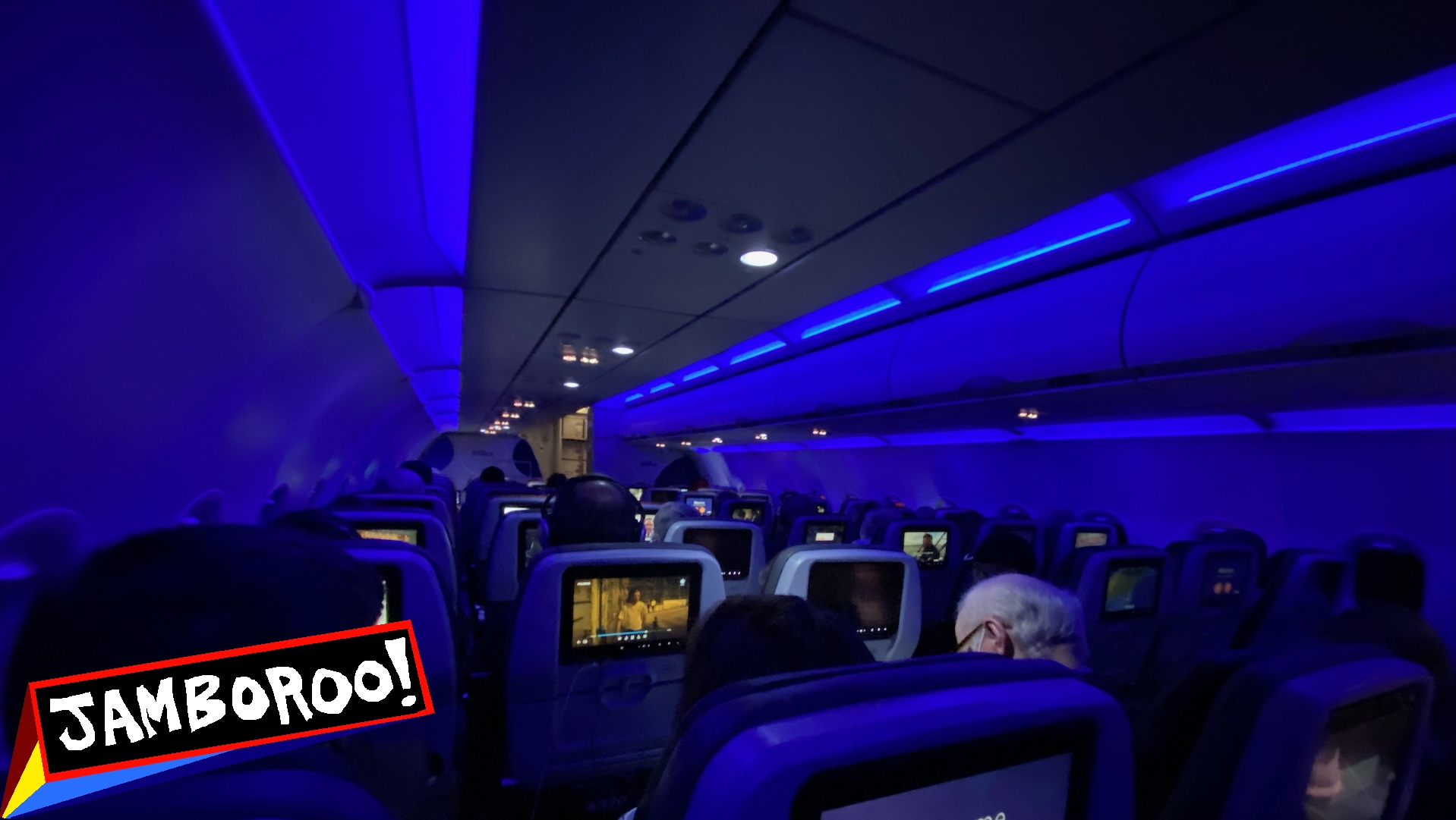Airplane cabin with in flight entertainment screens lit up, jetblue, New York.