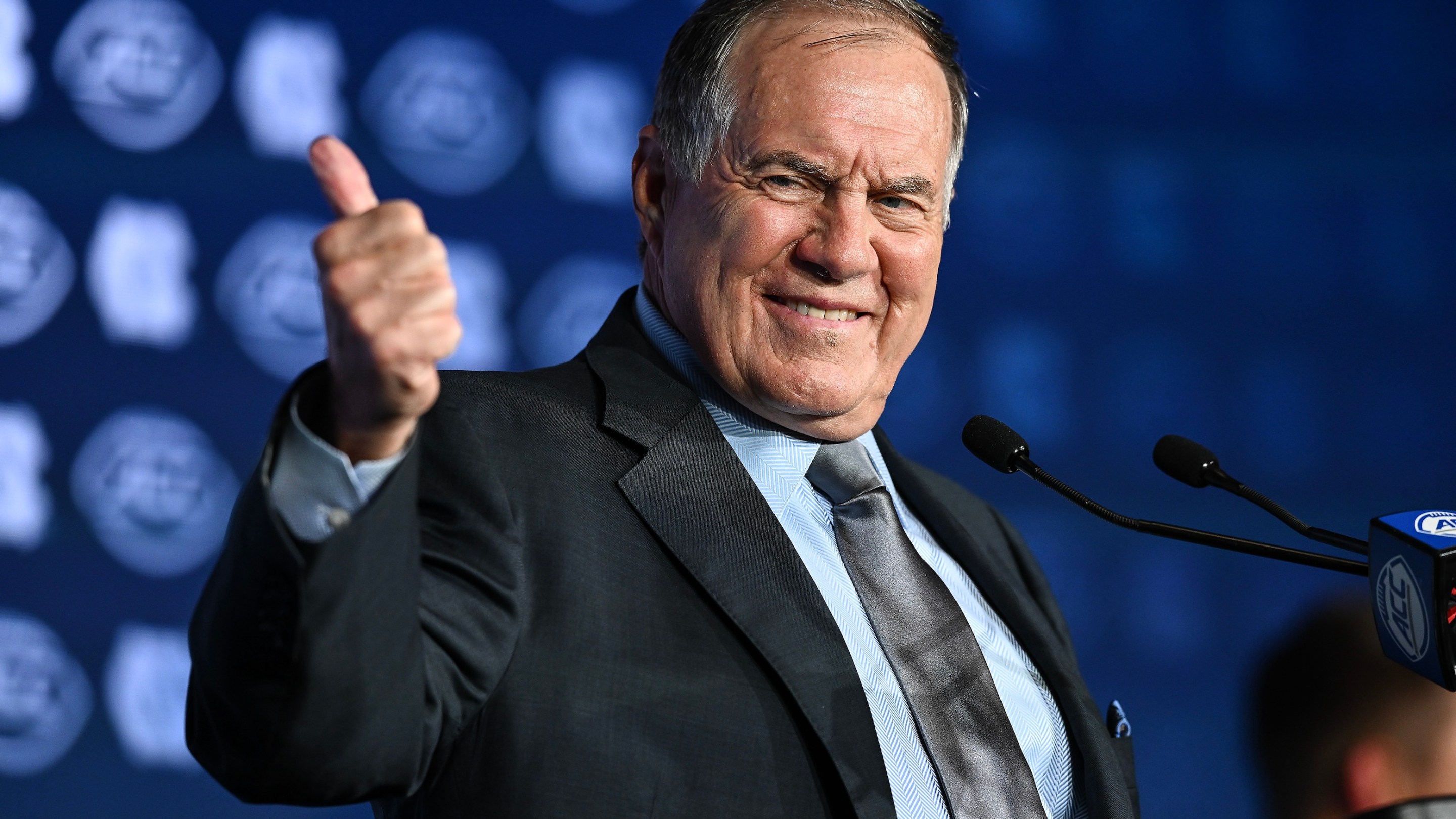 Head coach Bill Belichick of the North Carolina Tar Heels gives a thumbs up during the ACC Football Kickoff at Hilton Charlotte Uptown on July 24, 2025 in Charlotte, North Carolina. He looks real weird doing it.