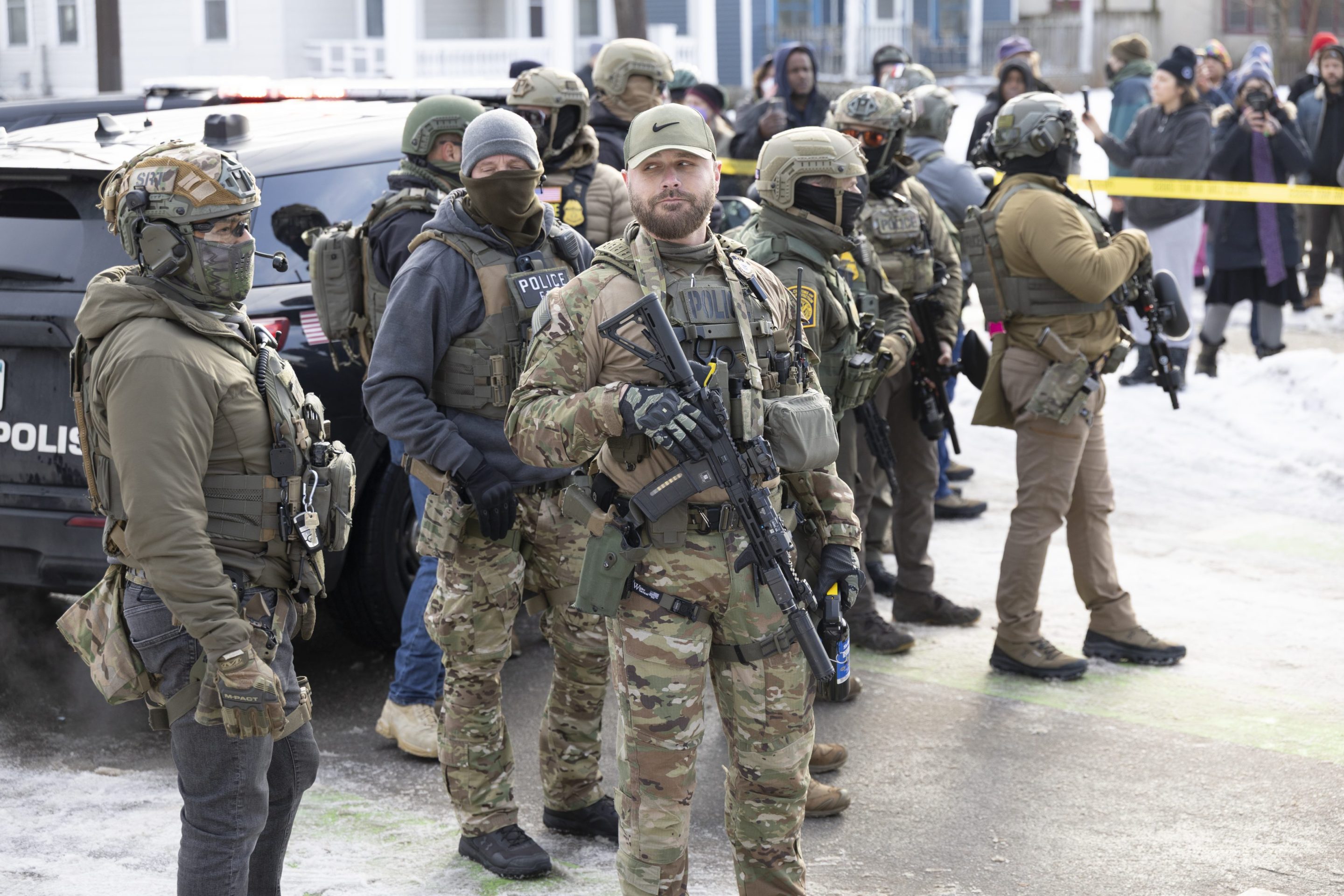 ICE agents stand at the scene where ICE agents fatally shot a woman earlier in the day in Minneapolis.