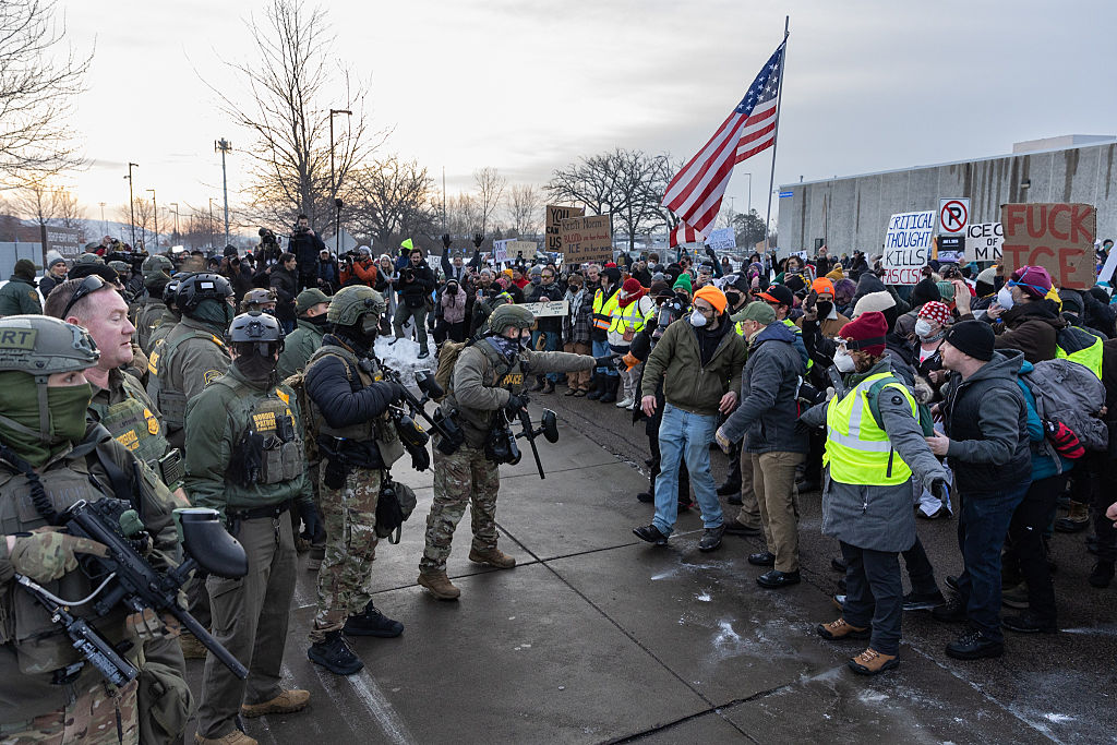 Protestors stare down federal officers with Immigration and Customs Enforcement outside a federal building near Minneapolis following the shooting of Renee Good by an ICE agent.