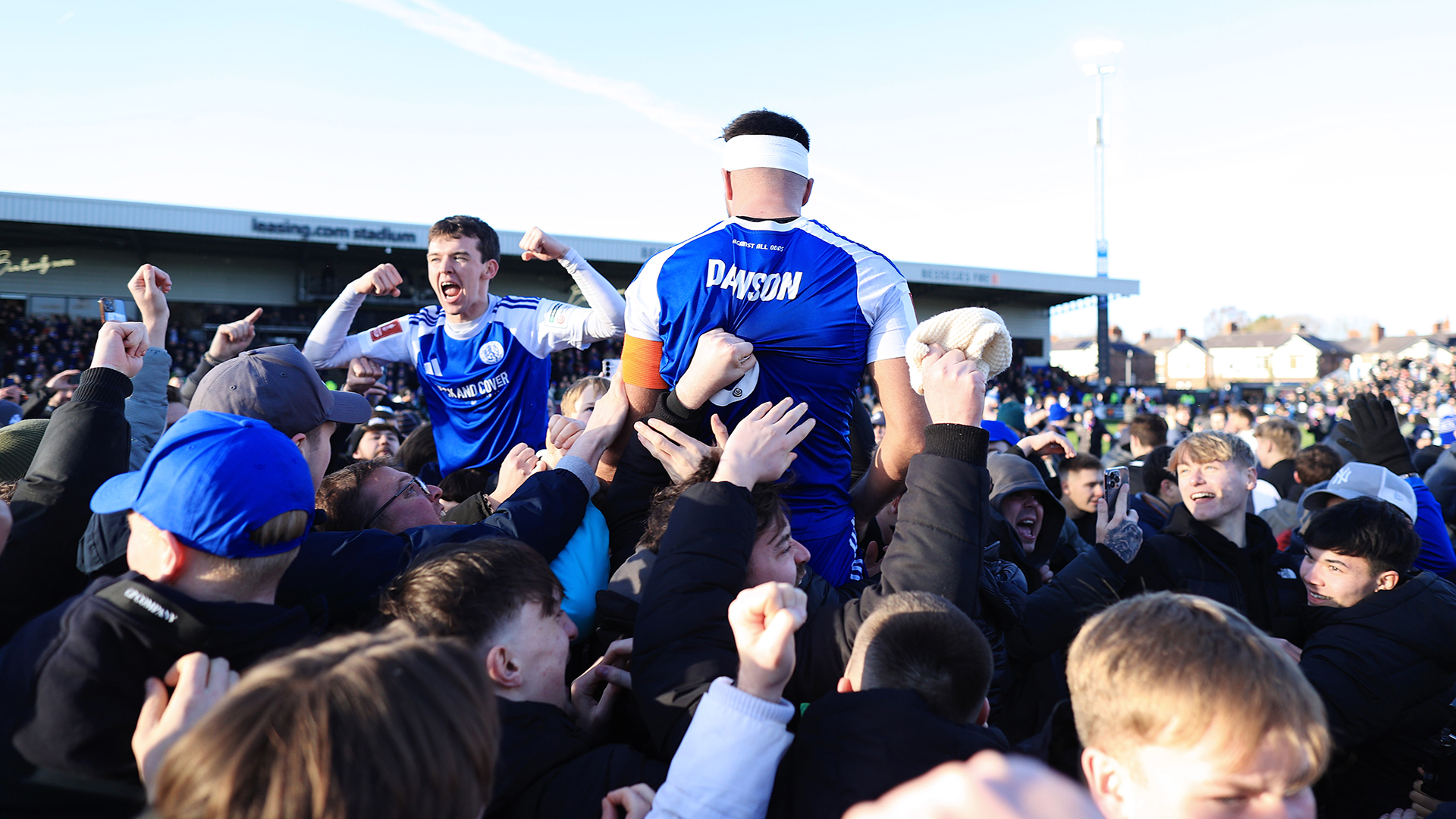 Fans hoist Luke Duffy of Macclesfield (L) and Paul Dawson of Macclesfield onto their shoulders as they celebrate victory after the Emirates FA Cup Third Round match between Macclesfield and Crystal Palace on January 10, 2026 in Macclesfield, England.