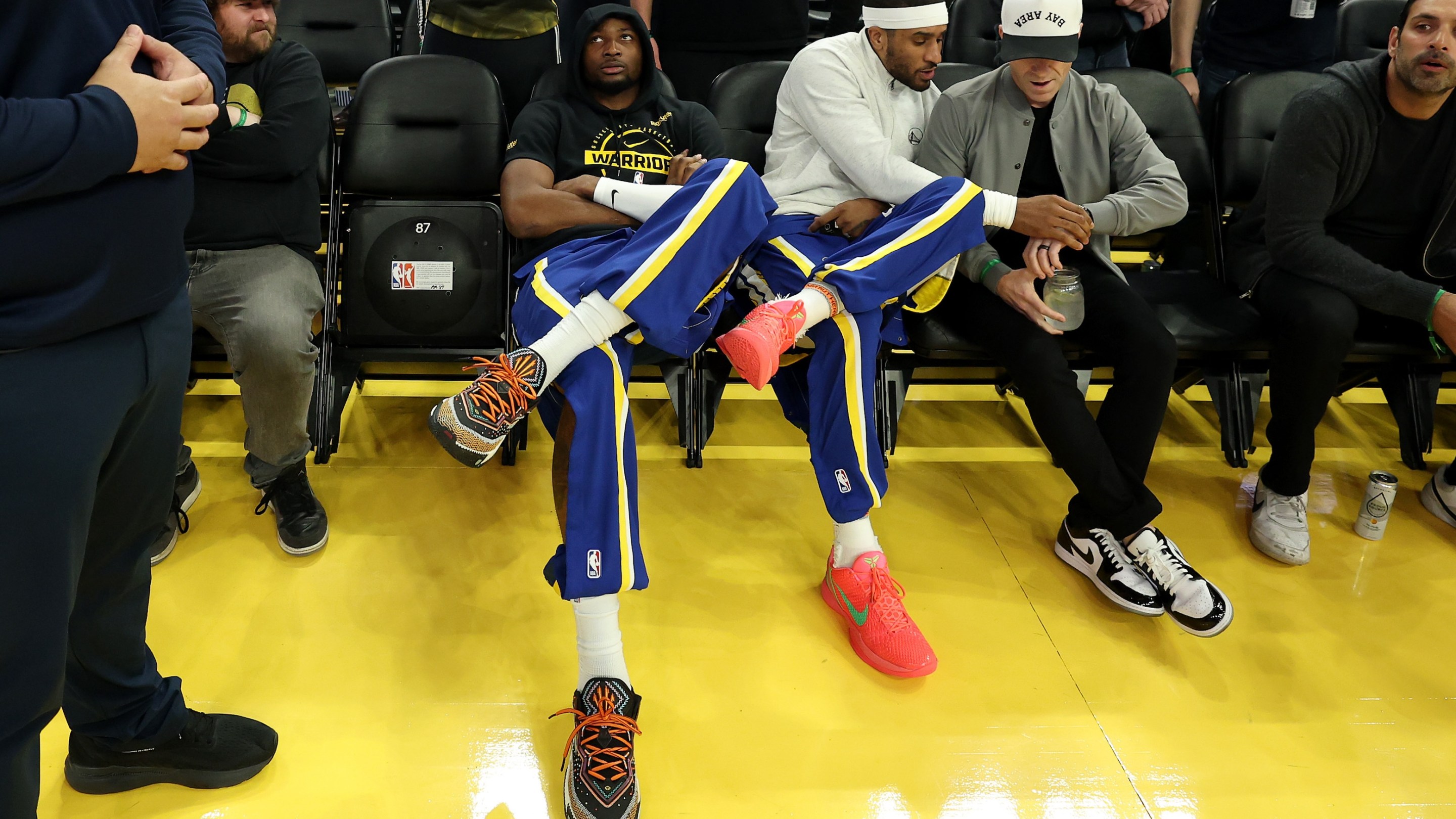 Jonathan Kuminga, at left, of the Golden State Warriors sit with fans before their game against the New York Knicks at Chase Center on January 15, 2026 in San Francisco, California.