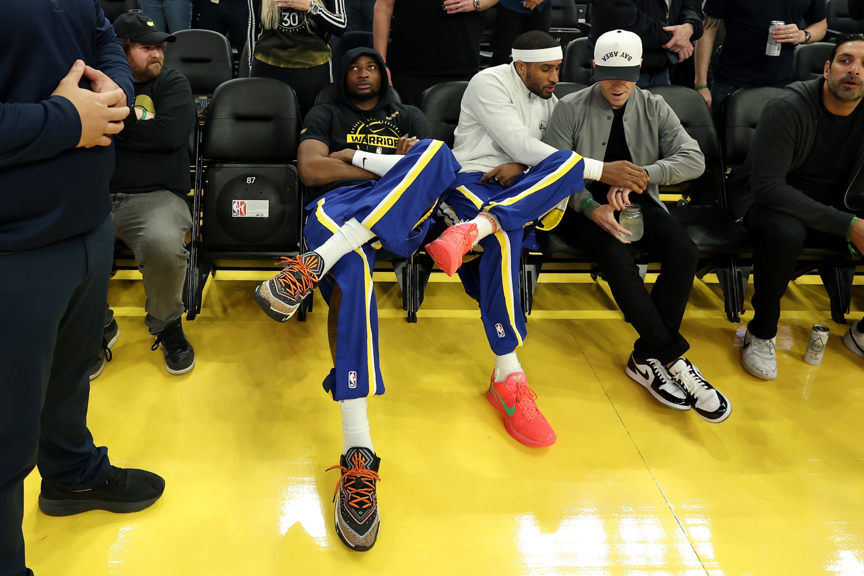 Jonathan Kuminga, at left, of the Golden State Warriors sit with fans before their game against the New York Knicks at Chase Center on January 15, 2026 in San Francisco, California.